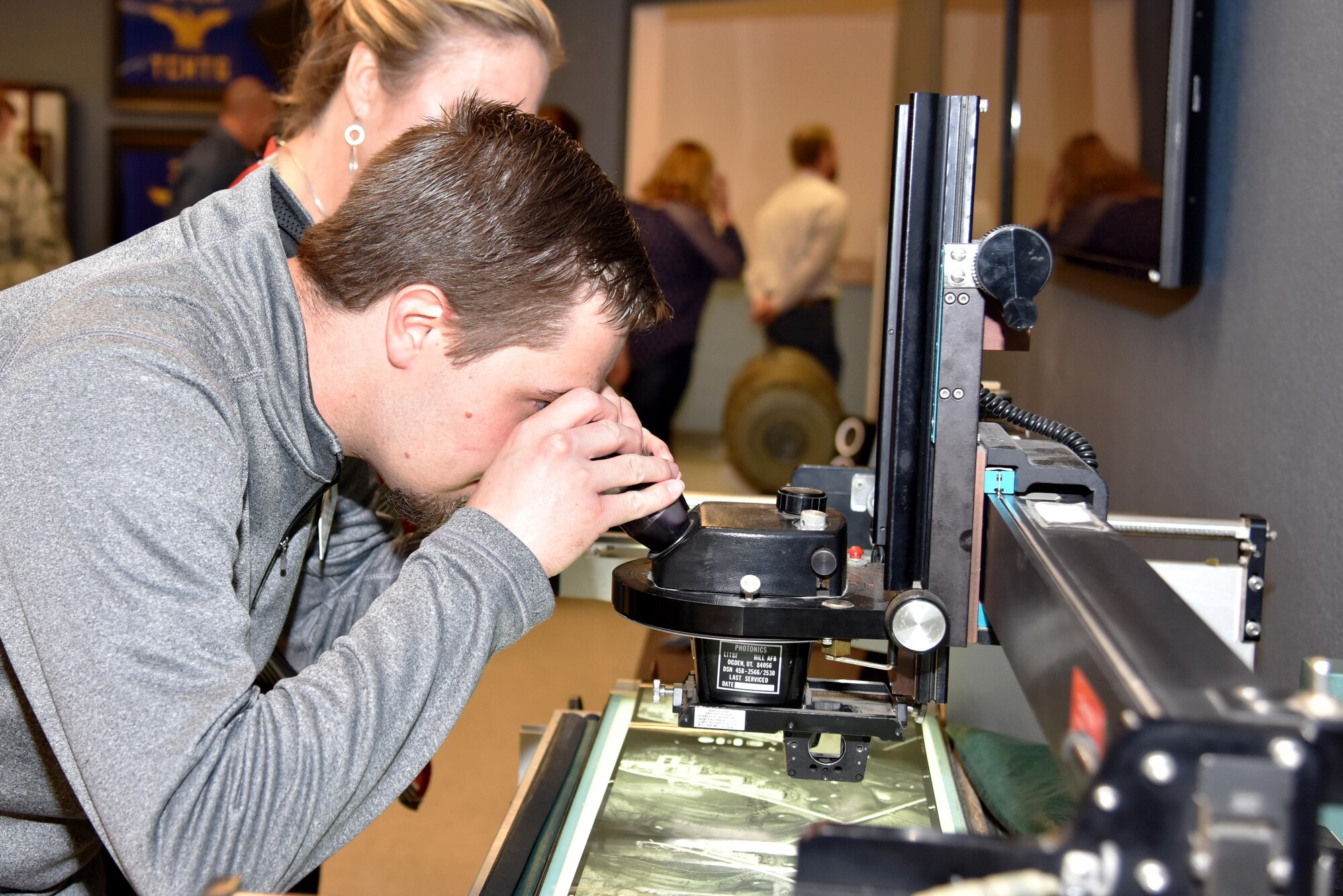 Steven Short and Laura Lewis, Leadership San Angelo members, look at an aerial photography heritage display during the LSA tour in the Di Tommaso Hall on Goodfellow Air Force Base, Texas, April 13, 2017. The visit consisted of a wing mission brief, trip to the 315th Training Squadron and a tour of the fire academy. (U.S. Air Force photo by Staff Sgt. Joshua Edwards/Released)