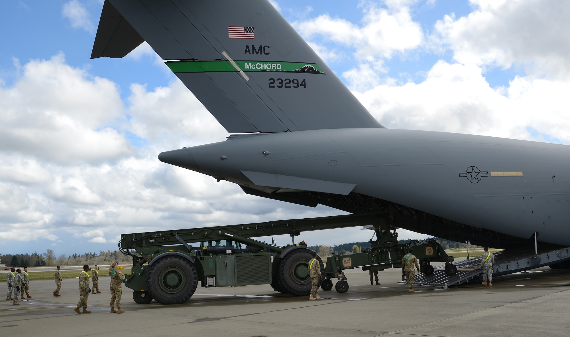 Airmen and Soldiers load a Rough Terrain Container Handler onto a C-17 Globemaster III during a Mission Oriented Training exercise April 13, 2017, at Joint Base Lewis-McChord, Wash. The RTCH weighs 121,000 pounds and is used for moving shipping containers. (U.S. Air Force photo/Senior Airman Jacob Jimenez) 