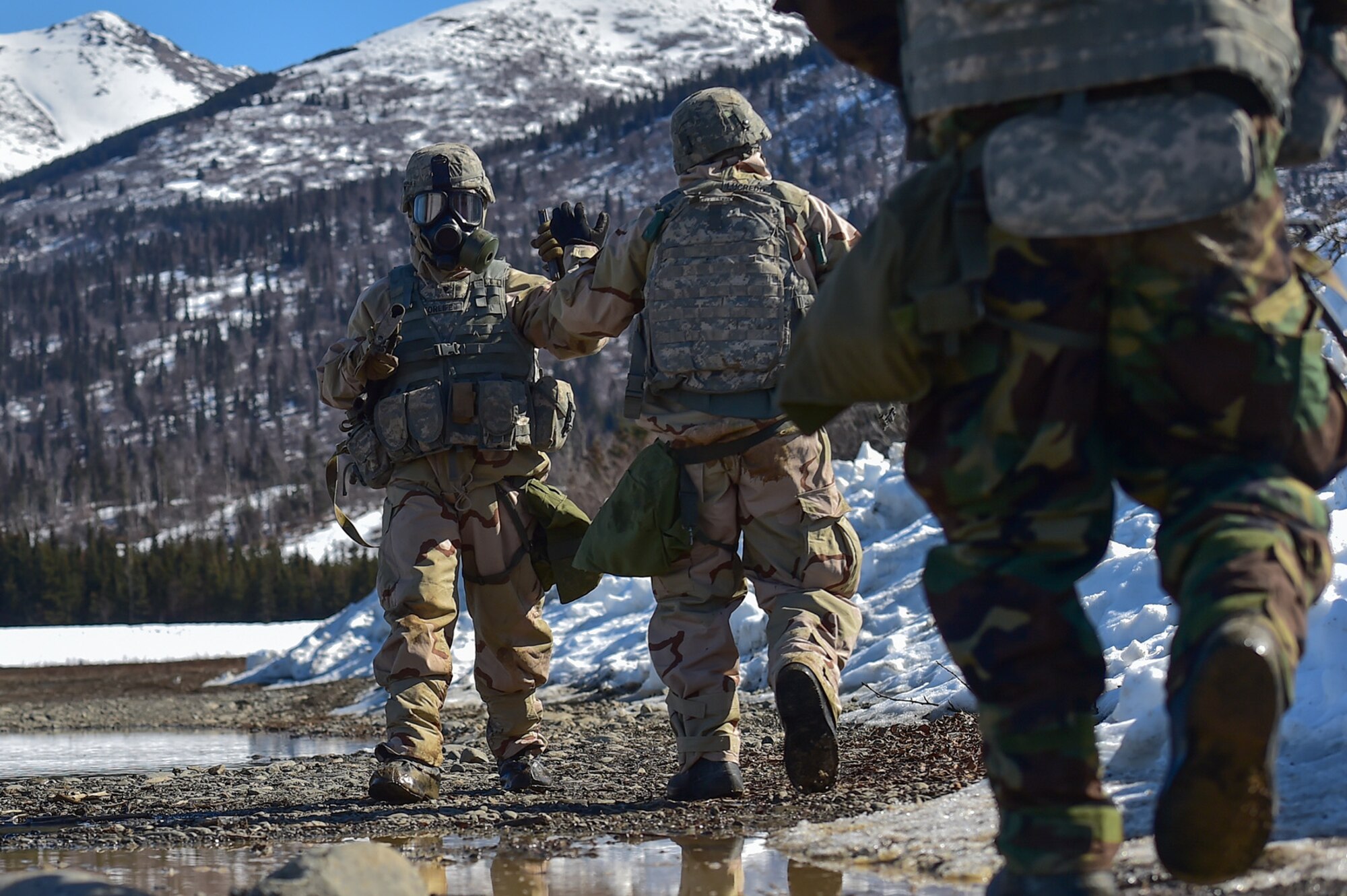 Spc. Michael Forlife, assigned to the 95th Chemical Company, “Arctic Dragons”, 17th Combat Sustainment Support Battalion, U.S. Army Alaska, fist bumps a fellow soldier after executing a Joint Service Lightweight Integrated Suit Technology stress fire at McGee range on Joint Base Elmendorf-Richardson, Alaska, April 13, 2017. The JSLIST is the product of a four-Service effort to field a common chemical protective clothing ensemble including a lightweight protective garment, multi-purpose overboots and gloves. 