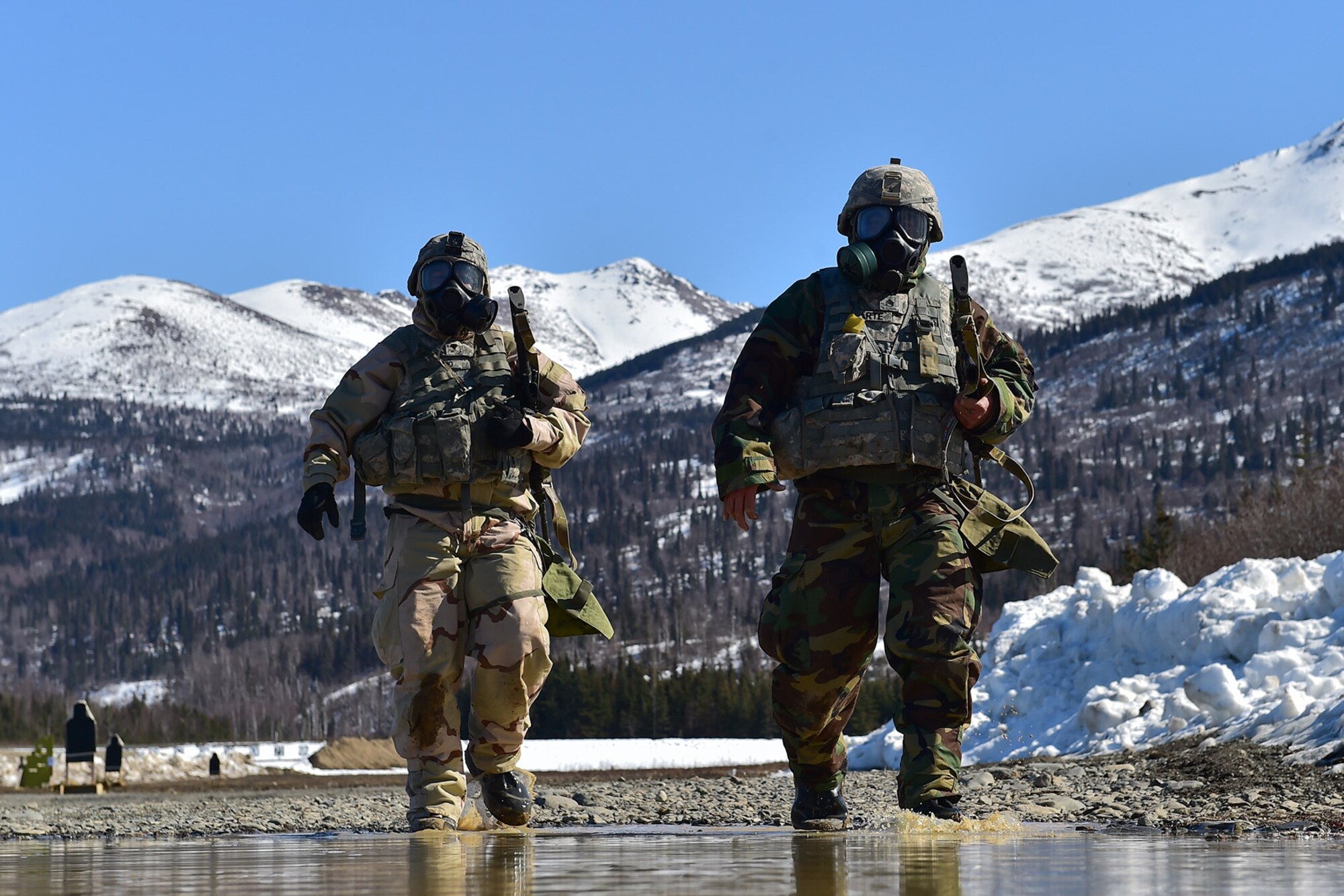 Spc. Francis Lucredo, a native of Los Angeles, left, and Army Staff Sgt. Norbert Iriarte, a native of Mangilao, Guam, both assigned to the 95th Chemical Company, “Arctic Dragons”, 17th Combat Sustainment Support Battalion, U.S. Army Alaska, walk off the firing line after a Joint Service Lightweight Integrated Suit Technology stress fire at McGee range on Joint Base Elmendorf-Richardson, Alaska, April 13, 2017. The JSLIST is the product of a four-Service effort to field a common chemical protective clothing ensemble including a lightweight protective garment, multi-purpose overboots and gloves.