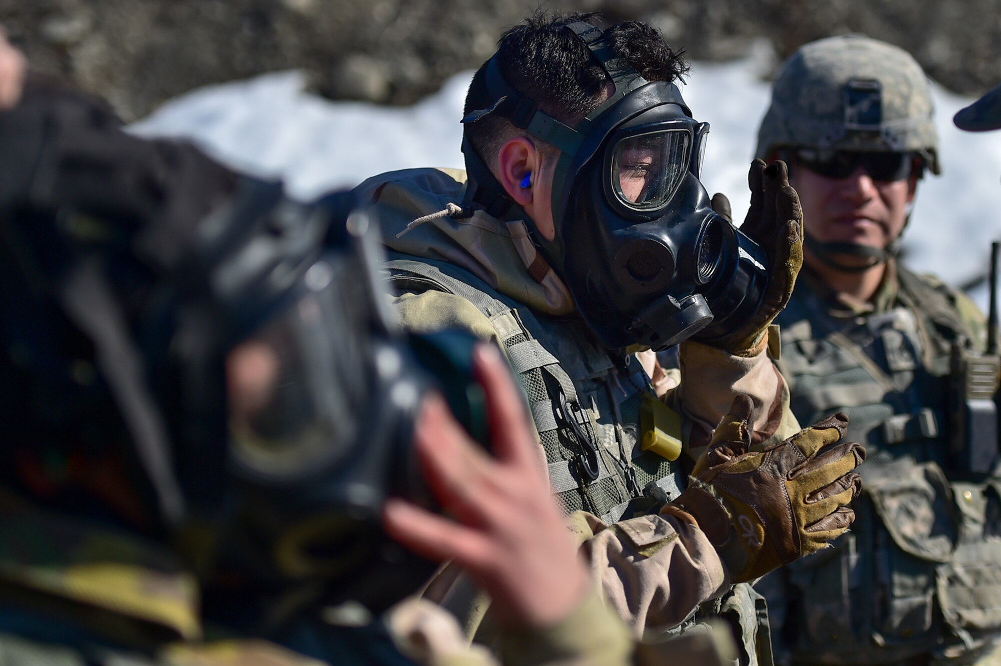 A soldier assigned to the 95th Chemical Company, “Arctic Dragons”, 17th Combat Sustainment Support Battalion, U.S. Army Alaska, checks the seal on his protective mask as he prepares to execute a Joint Service Lightweight Integrated Suit Technology stress fire at McGee range on Joint Base Elmendorf-Richardson, Alaska, April 13, 2017. The JSLIST is the product of a four-Service effort to field a common chemical protective clothing ensemble including a lightweight protective garment, multi-purpose overboots and gloves. 
