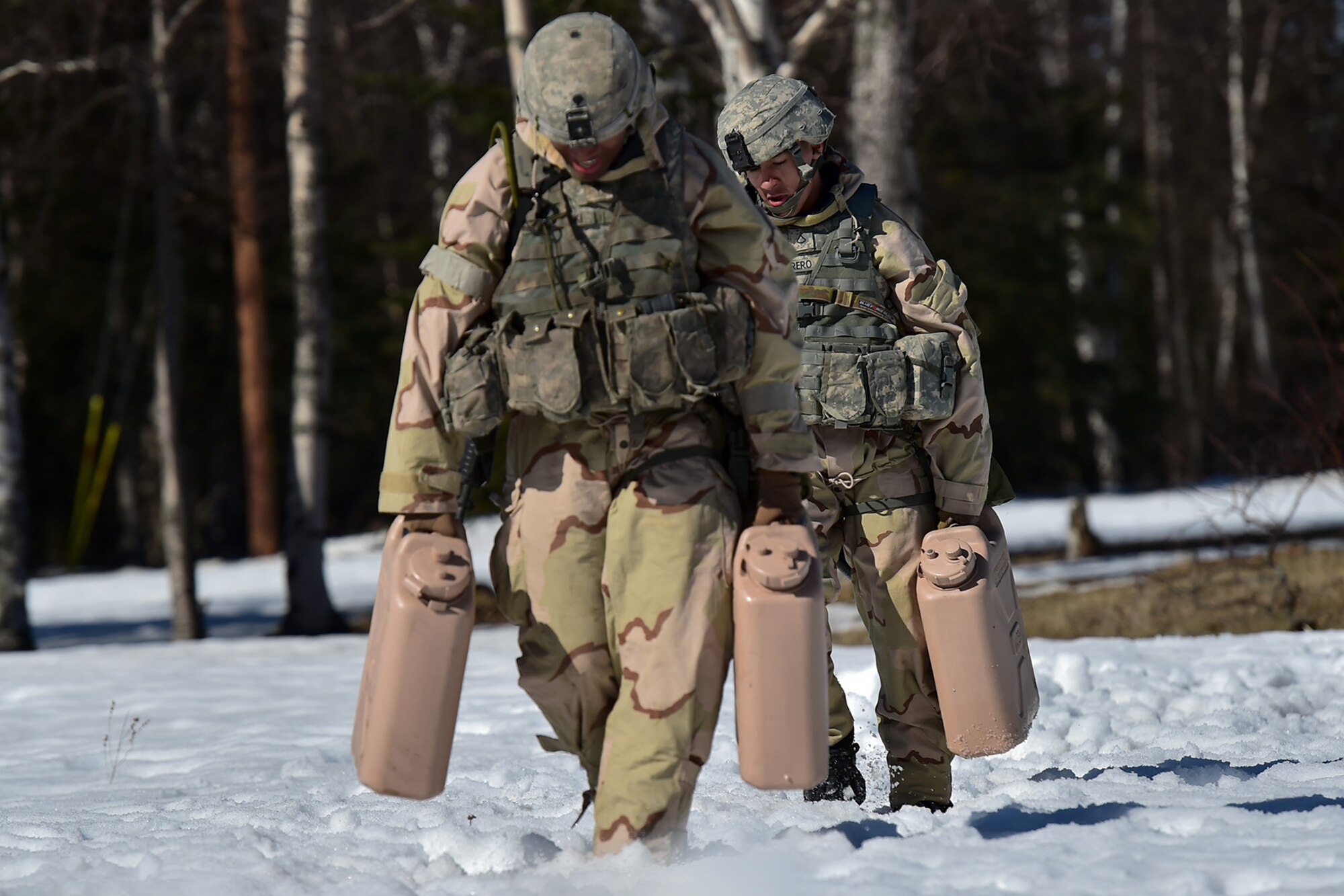 Spc. Diego Adamski, a native of Shelton, Wash., left, and Army Pfc. Esteban Guerrero, a native of Modesto, Calif., both assigned to the 95th Chemical Company, “Arctic Dragons”, 17th Combat Sustainment Support Battalion, U.S. Army Alaska, run with full water cans to raise their heart rates before executing a Joint Service Lightweight Integrated Suit Technology stress fire at McGee range on Joint Base Elmendorf-Richardson, Alaska, April 13, 2017. The JSLIST is the product of a four-Service effort to field a common chemical protective clothing ensemble including a lightweight protective garment, multi-purpose overboots and gloves. 