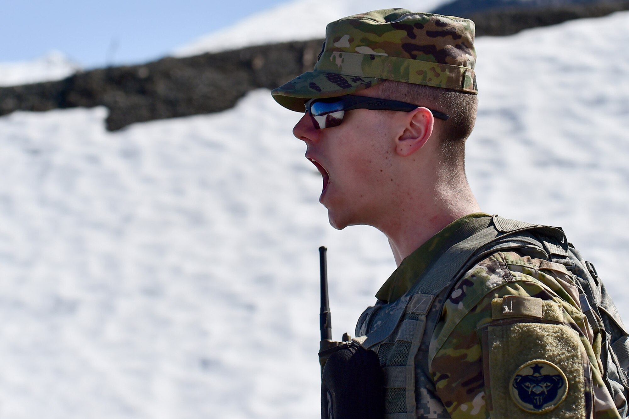 Spc. Bastian Ainsley, assigned to the 95th Chemical Company, “Arctic Dragons”, 17th Combat Sustainment Support Battalion, U.S. Army Alaska, yells orders to fellow Soldiers as they perform physical activities to elevate their heart rates before executing a Joint Service Lightweight Integrated Suit Technology stress fire at McGee range on Joint Base Elmendorf-Richardson, Alaska, April 13, 2017. The JSLIST is the product of a four-Service effort to field a common chemical protective clothing ensemble including a lightweight protective garment, multi-purpose overboots and gloves. 