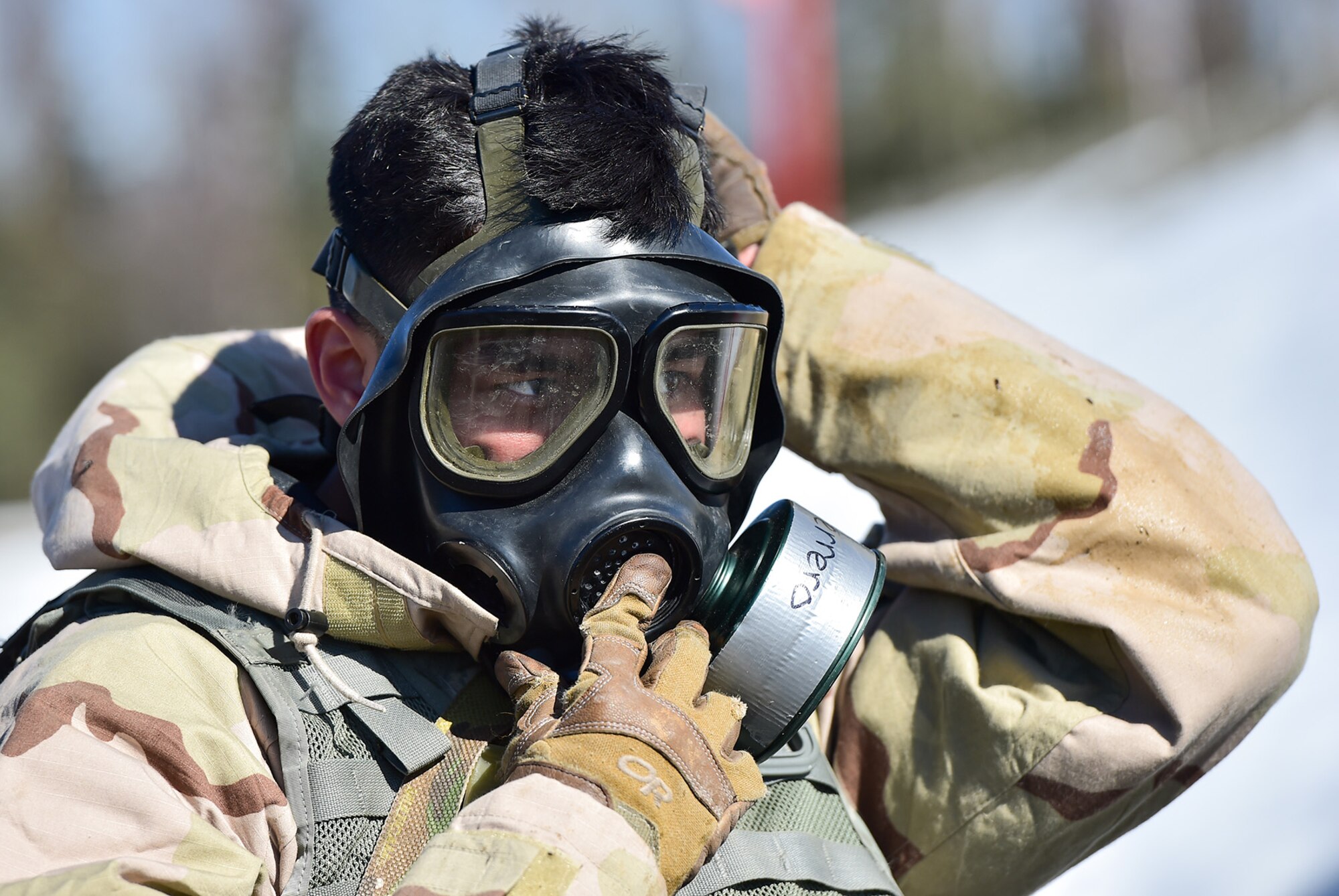Army Pfc. Esteban Guerrero, a native of Modesto, Calif., assigned to the 95th Chemical Company, “Arctic Dragons”, 17th Combat Sustainment Support Battalion, U.S. Army Alaska, donns his protective mask before executing a Joint Service Lightweight Integrated Suit Technology stress fire at McGee range on Joint Base Elmendorf-Richardson, Alaska, April 13, 2017. The JSLIST is the product of a four-Service effort to field a common chemical protective clothing ensemble including a lightweight protective garment, multi-purpose overboots and gloves. 