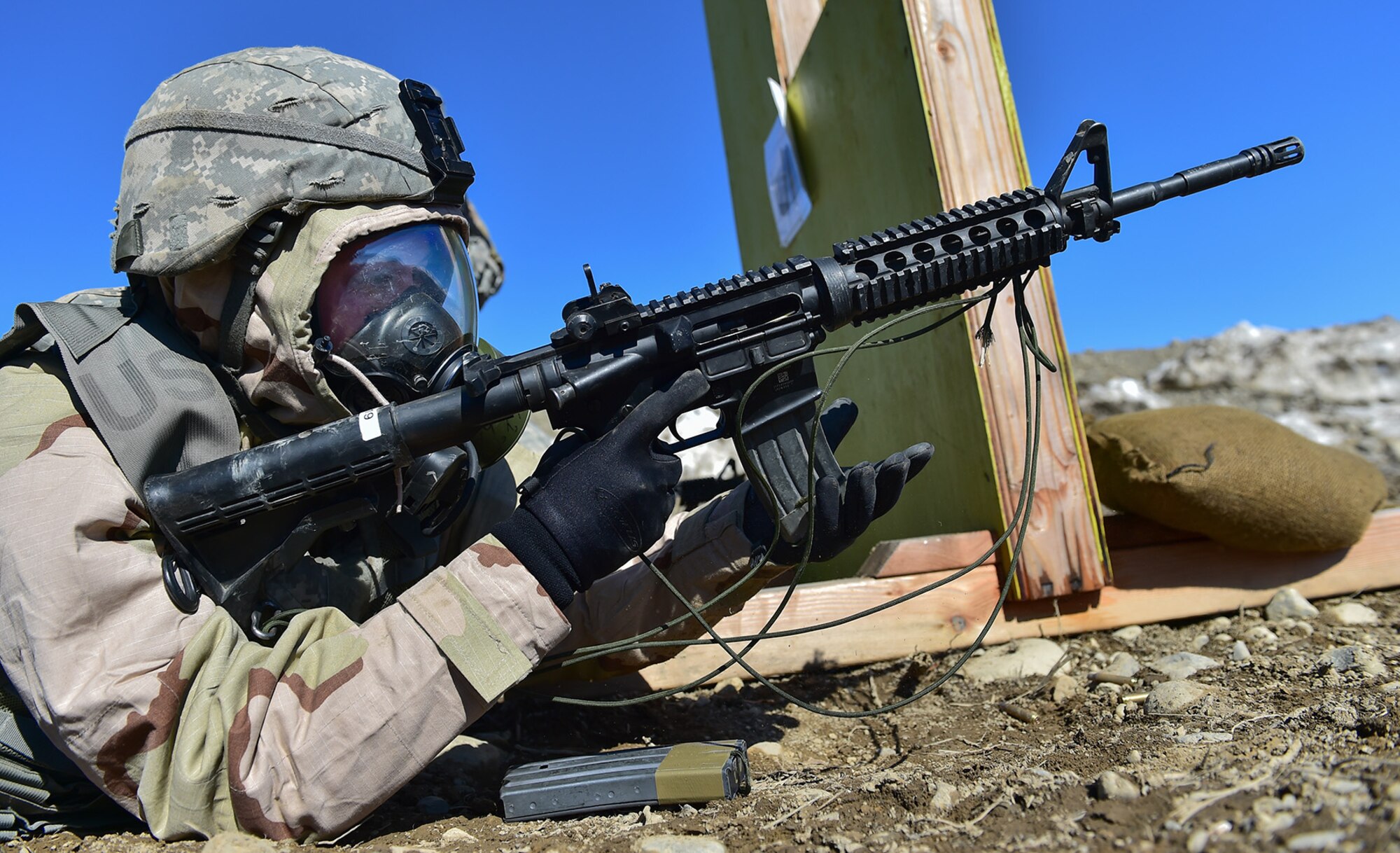 Spc. Katie McCarthy, a native of Punta Gorda, Fla., assigned to the 95th Chemical Company, “Arctic Dragons”, 17th Combat Sustainment Support Battalion, U.S. Army Alaska, reloads her M4 carbine as her battle buddy engages targets while executing a Joint Service Lightweight Integrated Suit Technology stress fire at McGee range on Joint Base Elmendorf-Richardson, Alaska, April 13, 2017. The JSLIST is the product of a four-Service effort to field a common chemical protective clothing ensemble including a lightweight protective garment, multi-purpose overboots and gloves. 