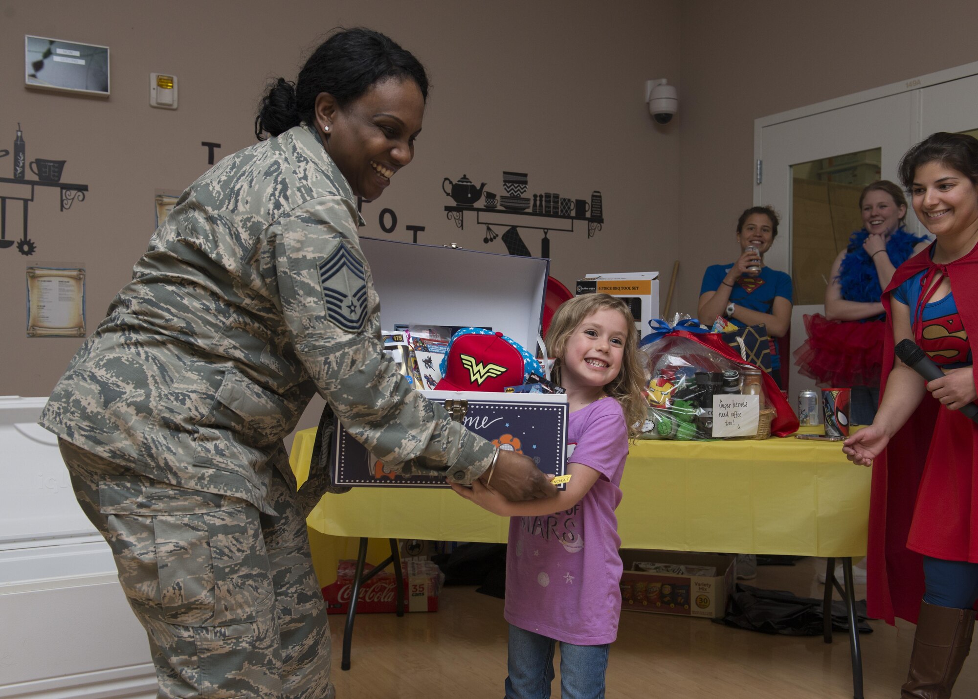 Chief Master Sgt. Erica Hammond, 436th Medical Group superintendent, helps carry a gift basket with Sophia Ehlers, daughter of Tech. Sgt. Ryan Ehlers, 436th Aerial Port Squadron load planning, at a Deployed Families Dinner April 13, 2017, at the Youth Center on Dover Air Force Base, Del. Ehlers was one of several attendees to win a door prize. (U.S. Air Force photo by Senior Airman Zachary Cacicia)