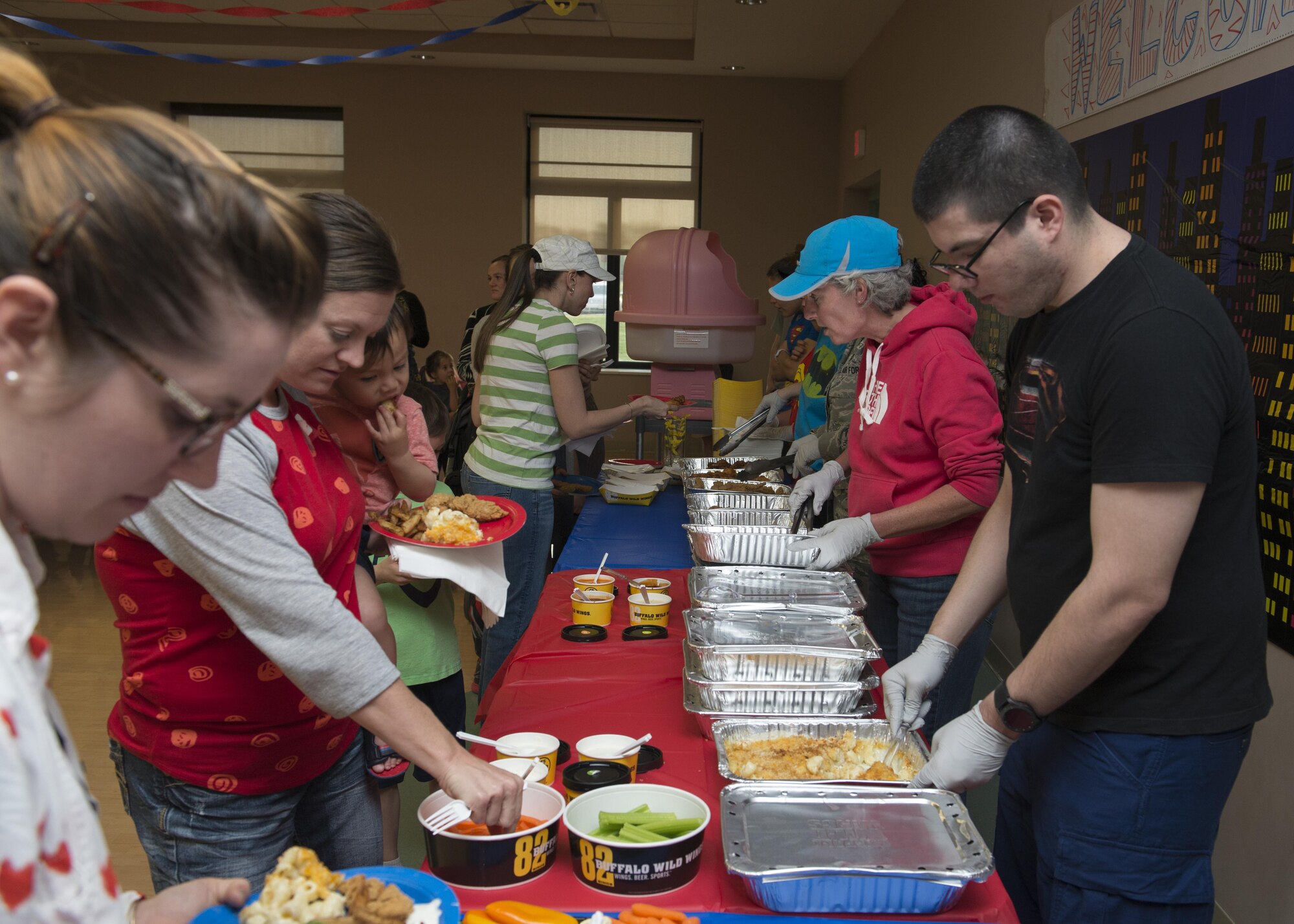 Family members of deployed Team Dover Airmen process through a buffet line at a Deployed Families Dinner April 13, 2017, at the Youth Center on Dover Air Force Base, Del. The dinner, held quarterly, was organized by the 436th Medical Group. (U.S. Air Force photo by Senior Airman Zachary Cacicia)