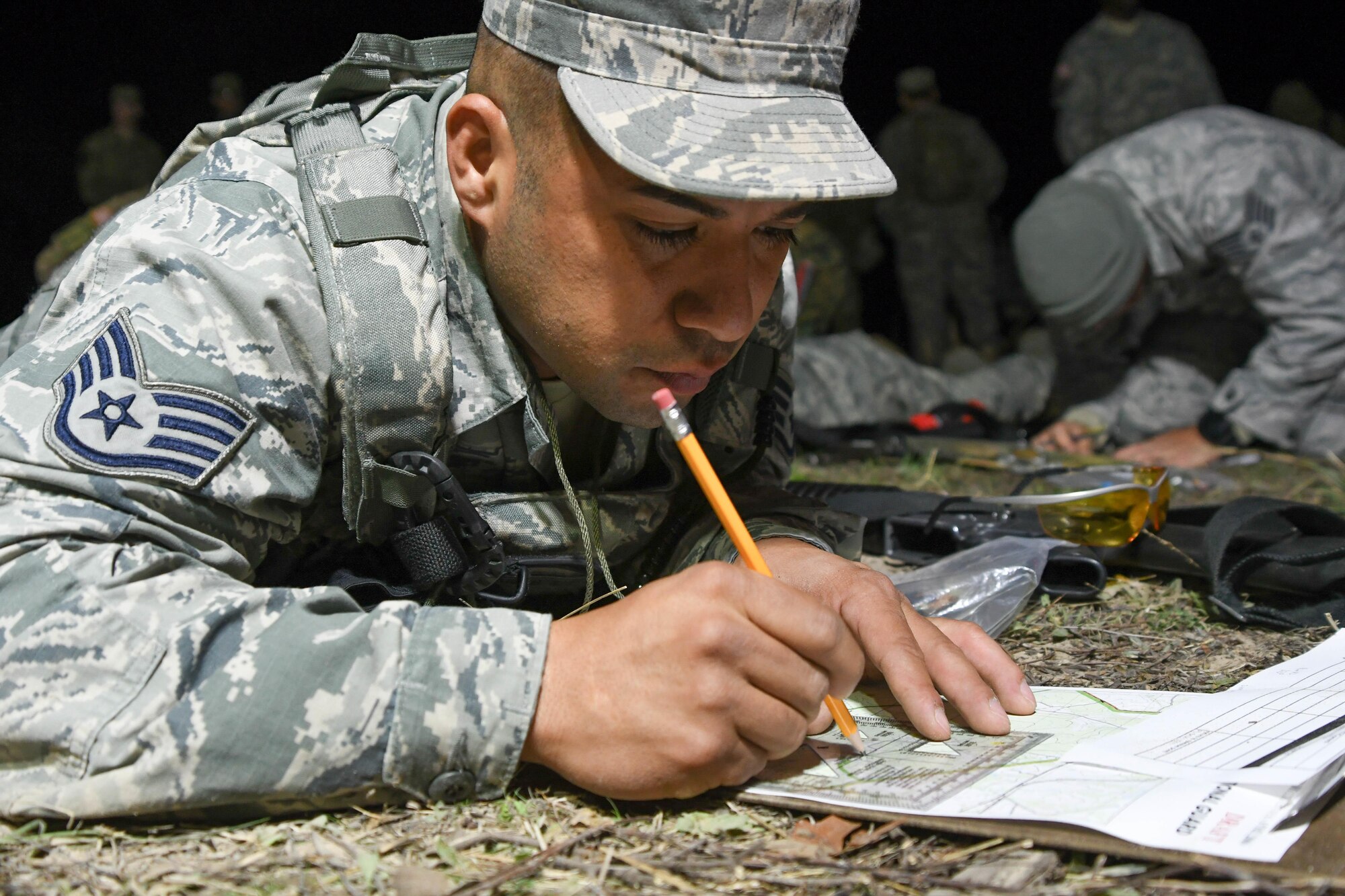 Air Force Staff Sgt. Juan Nunez, a security forces specialist with the 136th Security Forces Squadron, Texas Air National Guard, Fort Worth, Texas, plots points on his map during the land navigation event during the 2017 Texas Military Department Best Warrior Competition, March 2, 2017 at Camp Swift, near Bastrop, Texas. Land navigation tests the competitors ability to read maps, use a compass and other skills to traverse through unfamiliar terrain to different points throughout the course. (Air National Guard photo by Senior Airman De'Jon Williams)