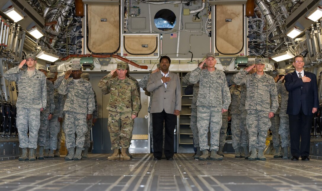 Capt. Brian Scallion, Air Force Mortuary Affairs Operations, Dignified Transfer officer in charge, left, and others render a salute as a transfer case of a simulated fallen service member is carried off of a C-17 Globemaster III during the Folded Flag 2017 mass casualty exercise April 11, 2017, on Dover Air Force Base, Del. Normally during a dignified transfer the DTOIC, chaplain, aircrew, escorts and leadership may be onboard the aircraft during the dignified transfer event. (U.S. Air Force photo by Roland Balik)