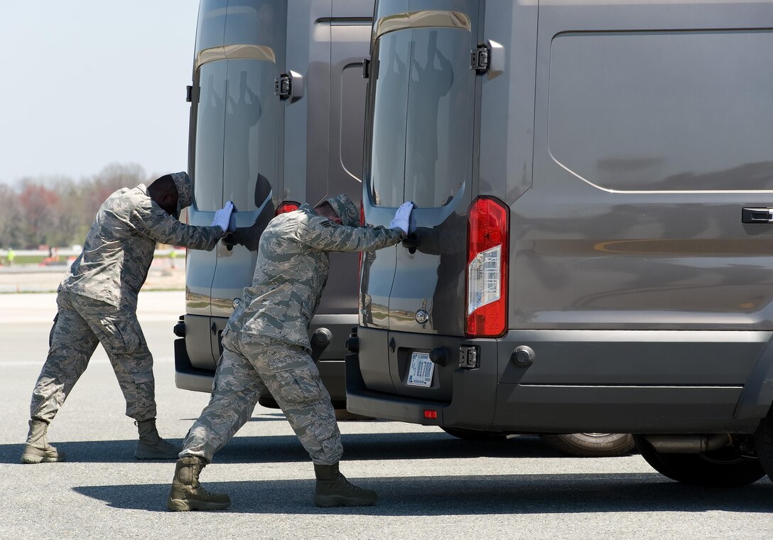Airman 1st Class Emmanuel Yeboah and Senior Airman Cody Kendall, both assigned to the Air Force Mortuary Affairs Operations, simultaneously close the doors of the mortuary transfer vehicles during Folded Flag 2017 April 11, 2017, on Dover Air Force Base, Del. U.S. Army and Marine Corps carry teams and AFMAO personnel participated in the joint service training exercise that tested the ability of AFMAO to respond to a mass casualty incident. (U.S. Air Force photo by Roland Balik)