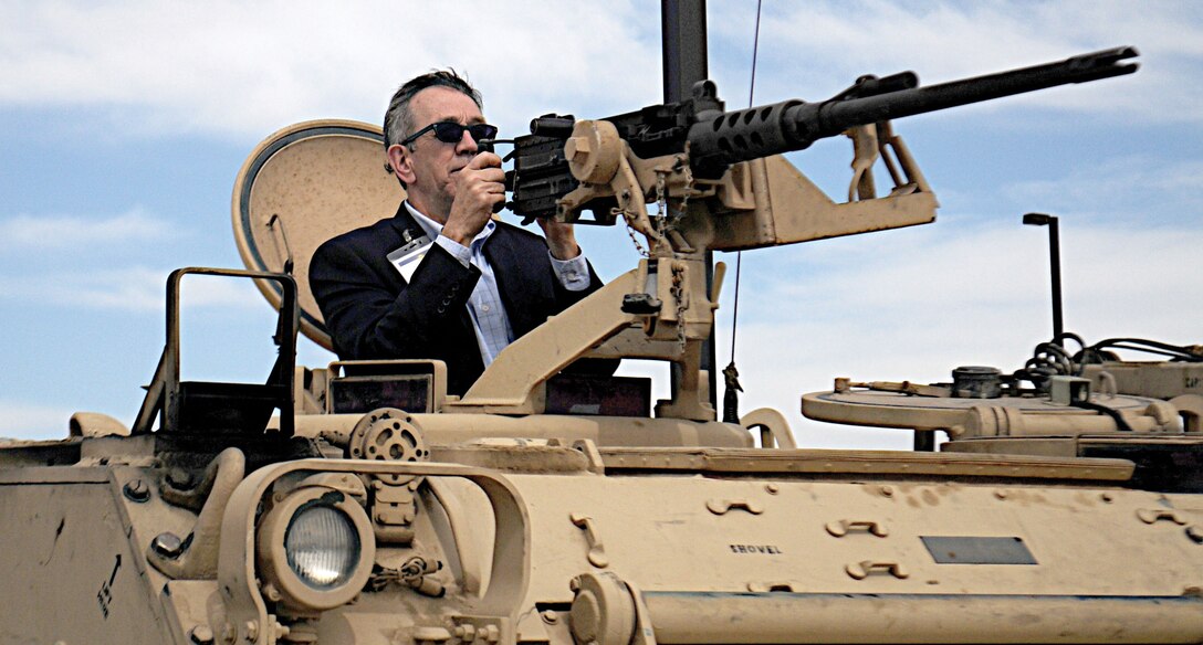 Frank Washburn, director, 448th Supply Chain Management Wing, Air Force Sustainment Center, learns what it takes to operate an M2 .50-caliber machine gun on an M113A3 Armored Personnel Carrier during an Adaptive Planning and Execution orientation program visit to Fort Carson March 22.  (Air Force photo by Capt. Shaun T. Manley)