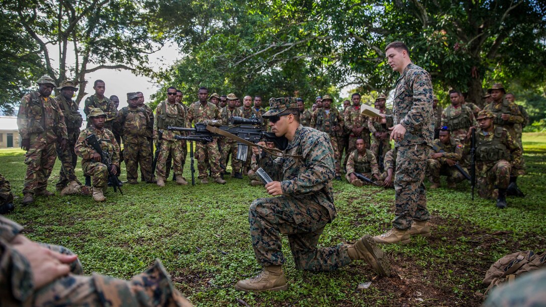 A U.S. Marine with Battalion Landing Team 1st Battalion, 4th Marine Regiment, 11th Marine Expeditionary Unit, demonstrates the tactical reload of an M27 Infantry Automatic Rifle to Papua New Guinea Defense Force service members during a military capabilities exchange at Taurama Barracks, Papua New Guinea as part of a theater security cooperation engagement, April 16. USS Comstock, with the embarked 11th MEU, is in Papua New Guinea to conduct activities and training that will enhance U.S.-Papua New Guinea relations as the two nations work together for a stable and prosperous Asia-Pacific region.