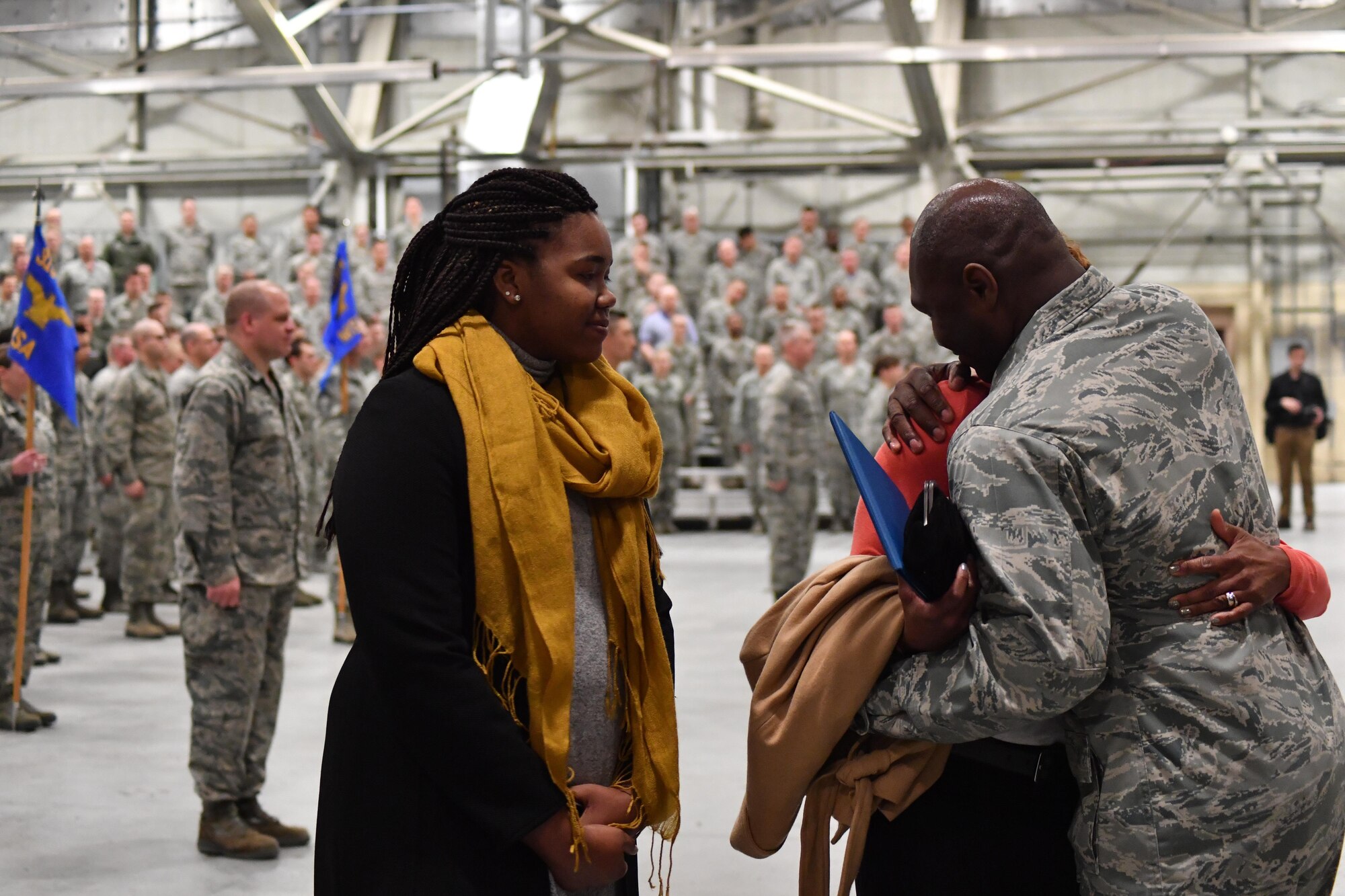 Col. Rodney Lewis, 319th Air Base Wing commander, embraces his wife as his daughter watches, after his final all call as the base commander on Grand Forks Air Force Base, N.D., April 14, 2017. Lewis and his family left Grand Forks AFB for the Pentagon as Lewis takes the position of director of the executive action group for the Air Force Chief of Staff. (U.S. Air Force photo by Airman 1st Class Elijaih Tiggs)