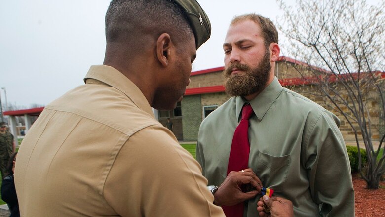Col. Ricardo Player (left), the Force Headquarters Group chief of staff, Marine Forces Reserve, pins the Navy and Marine Corps Medal on Cpl. Nathan Bryson (right), a Marine Corps veteran who most recently served as a motor transport operator for Headquarters and Support Battalion, School of Infantry East, Camp Lejeune, North Carolina, at the 3rd Battalion, 25th Marine Regiment headquarters in Brook Park, Ohio, April 14, 2017. Bryson was awarded the medal for his actions in 2014 when he and a fellow Marine saved a man from a burning vehicle. The Navy and Marine Corps Medal is awarded for acts of heroism despite personal risk and is the highest honor one can achieve for non-combat service. (U.S. Marine Corps Photo by Cpl. Dallas Johnson/Released)