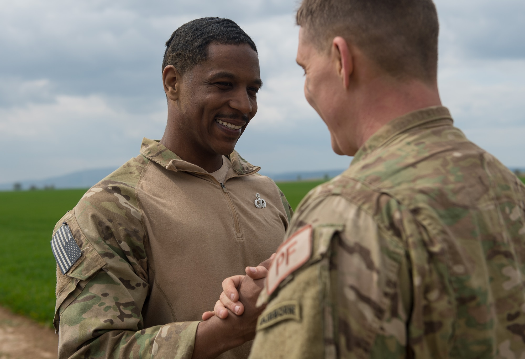 Robby Royster, 435th Security Forces Squadron close precision engagement team leader, shakes hands with Staff Sgt. Derek Halverson, 435th SFS personnel parachutist program manager, after Royster was awarded his master rated parachutist badge at Alzey, Germany, April 12, 2017. The master rated parachutist badge is an elite badge granted to few airborne service members which Royster earned with less than ten years in service. (U.S. Air Force photo by Staff Sgt. Nesha Humes)
