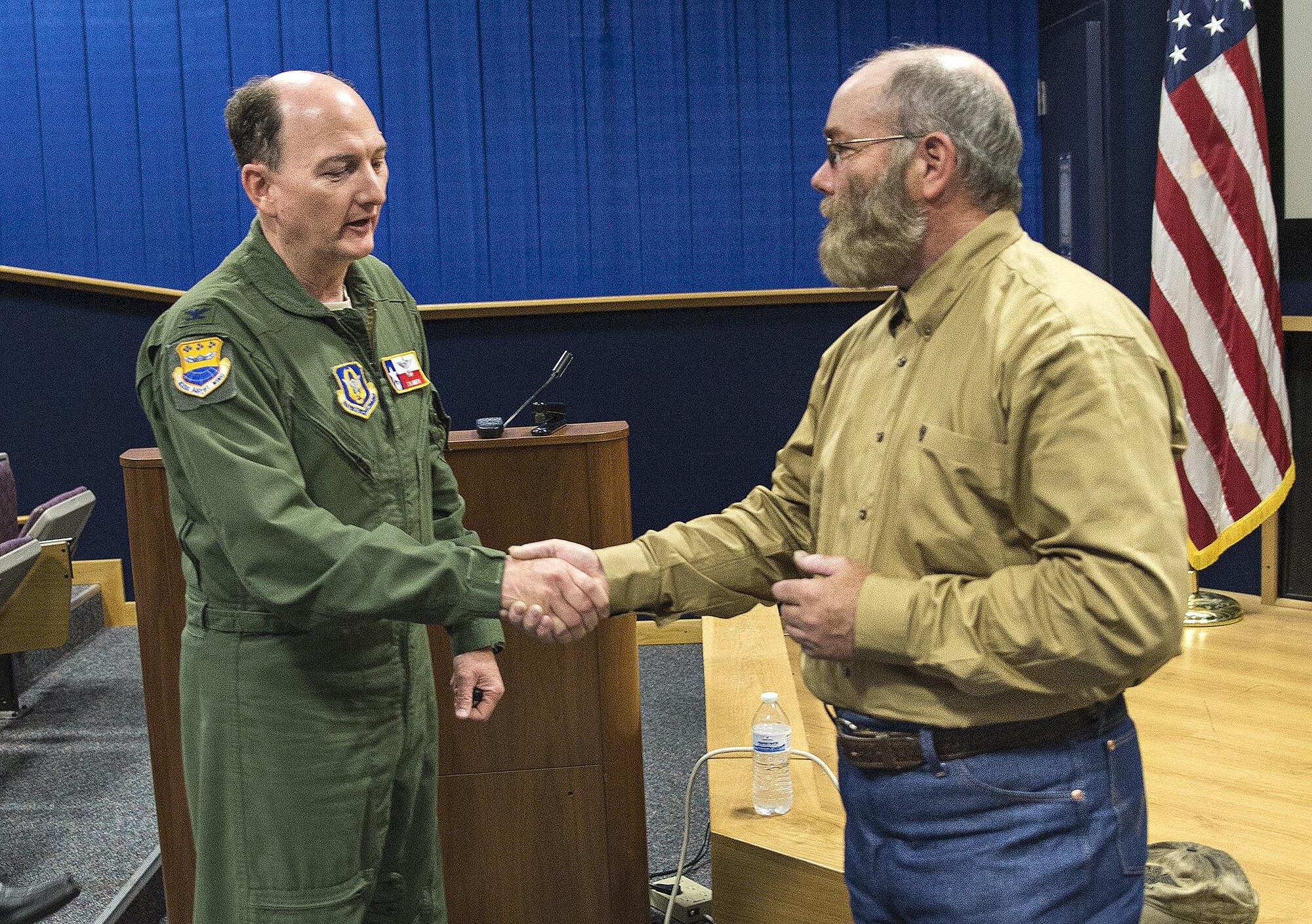 Col. Thomas K. Smith, Jr., 433rd Airlift Wing commander, coins Thomas Hamill on April 13, 2017 at Joint Base San Antonio-Lackland. Hamill was a government-contracted truck driver during the Iraq War in 2004, when his convoy was ambushed and he was taken prisoner. The speech focused on being resilient and never giving up in the face of danger.  (U.S.  Air Force photo by Benjamin Faske)
