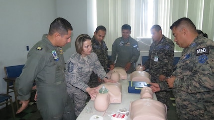 Lt. Col. Dan Brown (left), U.S. Air Force School of Aerospace Medicine Volunteer Emergency Medicine instructor, changes the patient’s (actor) vital signs to critical during a static aircraft patient transport simulation as Honduran doctor Jimmy Cruz Membreño (center) begins a patient reassessment.