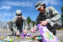 Maj. Christine Pasun (right), 50th Operations Support Squadron assistant director of operations, and 2nd Lt. Walker Fickling, 50th Force Support Squadron deputy of sustainment services, crack open their loot while others continue to search during the 2nd Annual Easter Egg Hunt at Schriver Air Force Base, Colorado, Wednesday, April 12, 2017. The 50th Space Wing Chaplains Office hosted the event as a way to get some air and allow Airmen to be kids again.  (U.S. Air Force photo/Christopher DeWitt)