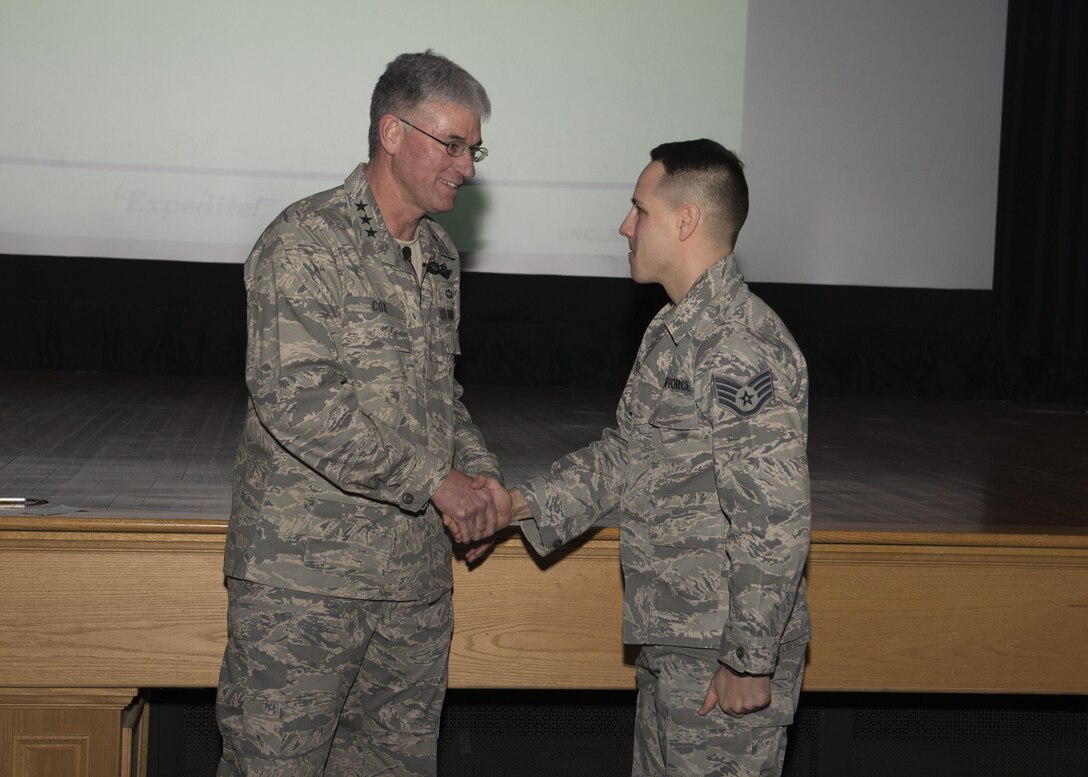 Lt. Gen. Samuel Cox, 18th Air Force commander, shakes the hand of Staff Sgt. Chad Hardesty, 436th Force Support Squadron Airman Leadership School instructor, during an all call March 2, 2017, at Dover Air Force Base, Del. Cox informed Hardesty that he was one of 14 Air Mobility Command members selected to receive a promotion through the Stripes for Exceptional Performers promotion program. The STEP promotion program offers commanders a limited opportunity to immediately promote enlisted members to staff sergeant, technical sergeant or master sergeant. (U.S. Air Force photo by Zachary Cacicia)