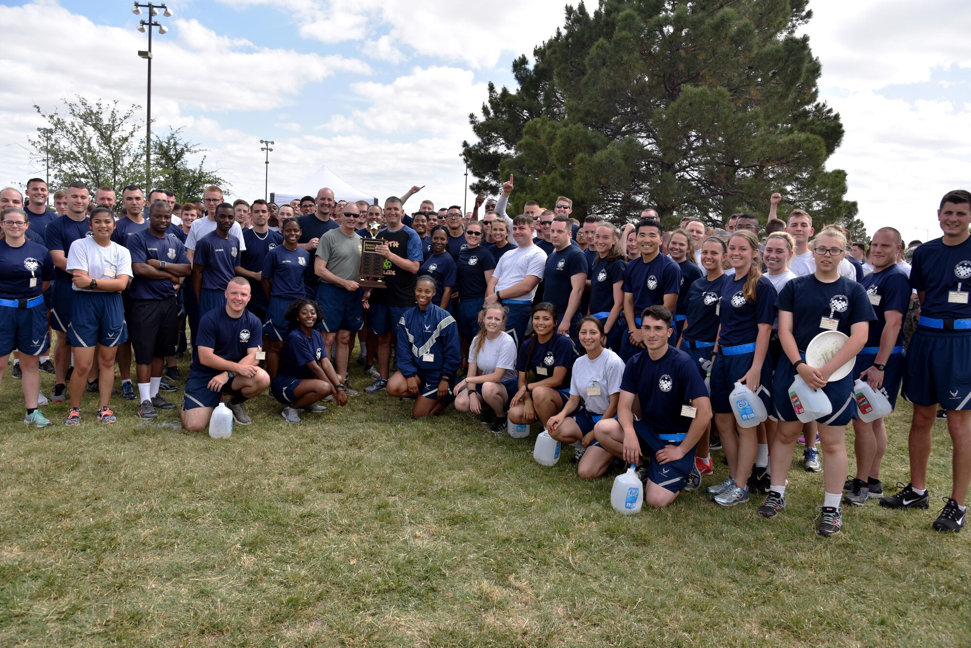 U.S. Air Force Col. Michael Downs, 17th Training Wing Commander, awards the sports day trophy to the 315th Training Squadron near the Mathis Fitness Center on Goodfellow Air Force Base, Texas, April 14, 2017. The 315th TRS placed in the top four teams, then went on to win the winner-take-all tug-of-war competition. (U.S. Air Force photo by Staff Sgt. Joshua Edwards/Released)