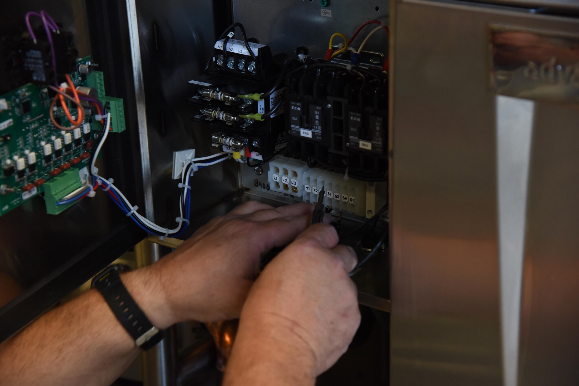 Bo Langford, R and R Food Service installer, connects the solenoid for the garbage disposal at McBride Commons April 11, 2017, on Keesler Air Force Base, Miss. The McBride Commons renovation project will transition the former base library into a common area for those with base access, which includes a children’s library, computer stations, engraving, framing, marketing and print shops and a full kitchen. The planned completion date for the nine-month project is May 2017. (U.S. Air Force photo by Kemberly Groue)