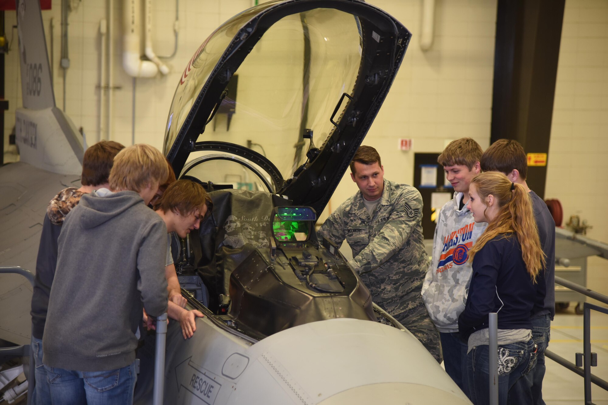 Sioux Falls, S.D. - Staff Sgt. Matt McCarthy, 114th Aircraft Maintenance Squadron electronic systems integrated mechanic, explains the function of an F-16 cockpit to students during the first night flying career day April 13, 2017, Joe Foss Field, S.D. Career day allows students, parents, and others who are interested in the South Dakota Air National Guard to see and learn about the different vocations the 114th Fighter Wing Airmen perform on a daily basis. (U.S. Air National Guard photo by Staff Sgt. Duane Duimstra/Released)