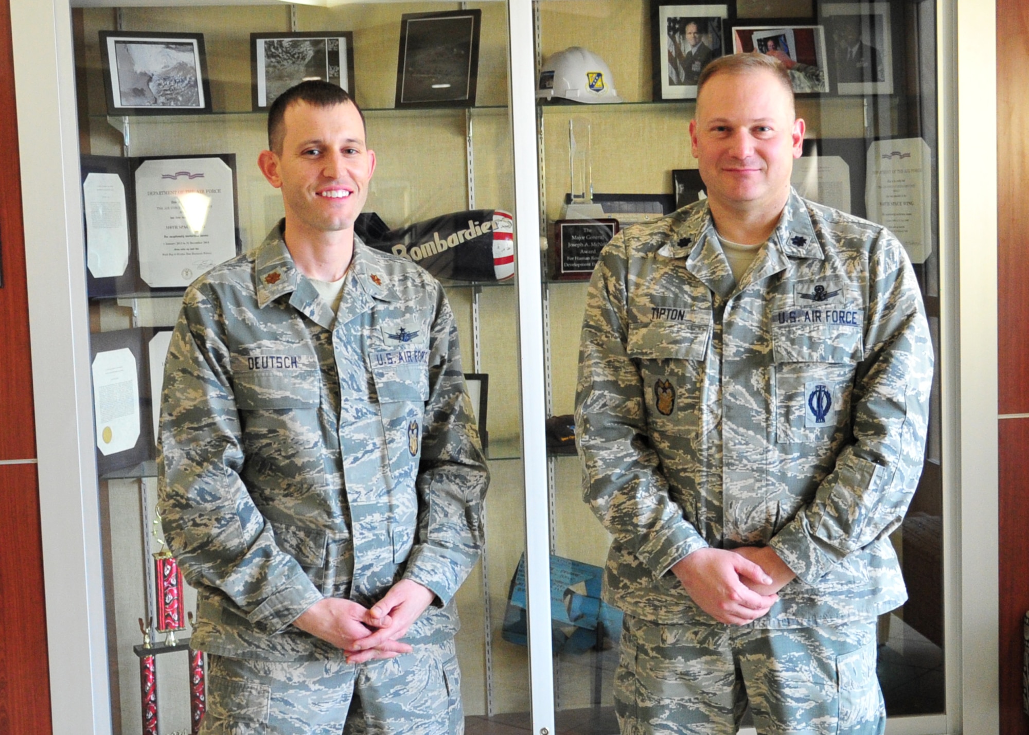 SCHREIVER AIR FORCE BASE, Colo. -- Maj. Paul Deutsch, Director of the 310th Space Wing Inspector General Complaints Resolution Program, and Lt. Col. Jerade Tipton, 310th SW/IG Complaints Resolution Management, stand in front of the wings awards display case on Sunday, Mar. 5th, 2017. The team won the 2016 John P. Flynn award due to their embodiment of integrity, justice, compassion, loyalty, courage and spirit within their office. (U.S. Air Force photo/Senior Airman Laura Turner)