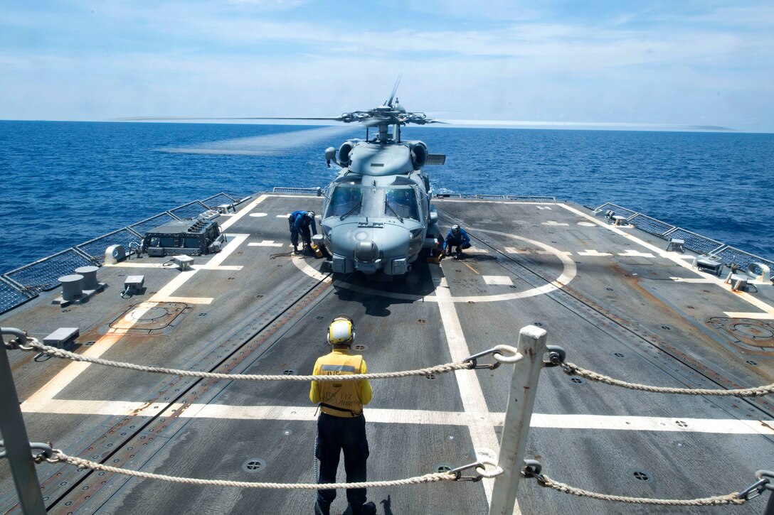 Sailors remove safety chocks and chains before an MH-60R Seahawk helicopter takes off from the flight deck of the guided-missile destroyer USS Michael Murphy in the South China Sea, April 12, 2017. The helicopter crew is assigned to Maritime Helicopter Strike Squadron 37. Navy photo by Petty Officer 3rd Class Danny Kelley
