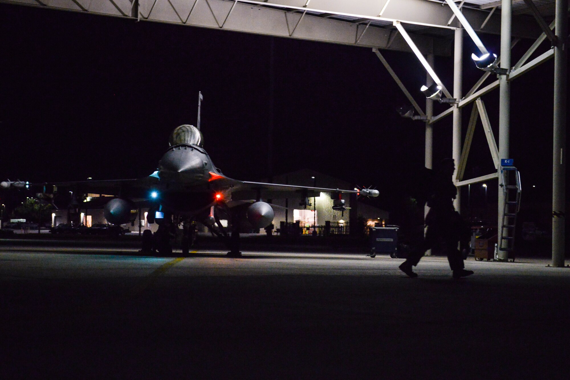 A U.S. Airman walks past an F-16CM Fighting Falcon after the aircraft returned from a night flight at Shaw Air Force Base, S.C., April 13, 2017. The Shaw flightline runs 24-hour operations to ensure combat-ready aircraft and Airmen anytime, anywhere. (U.S. Air Force photo by Airman 1st Class Destinee Sweeney)