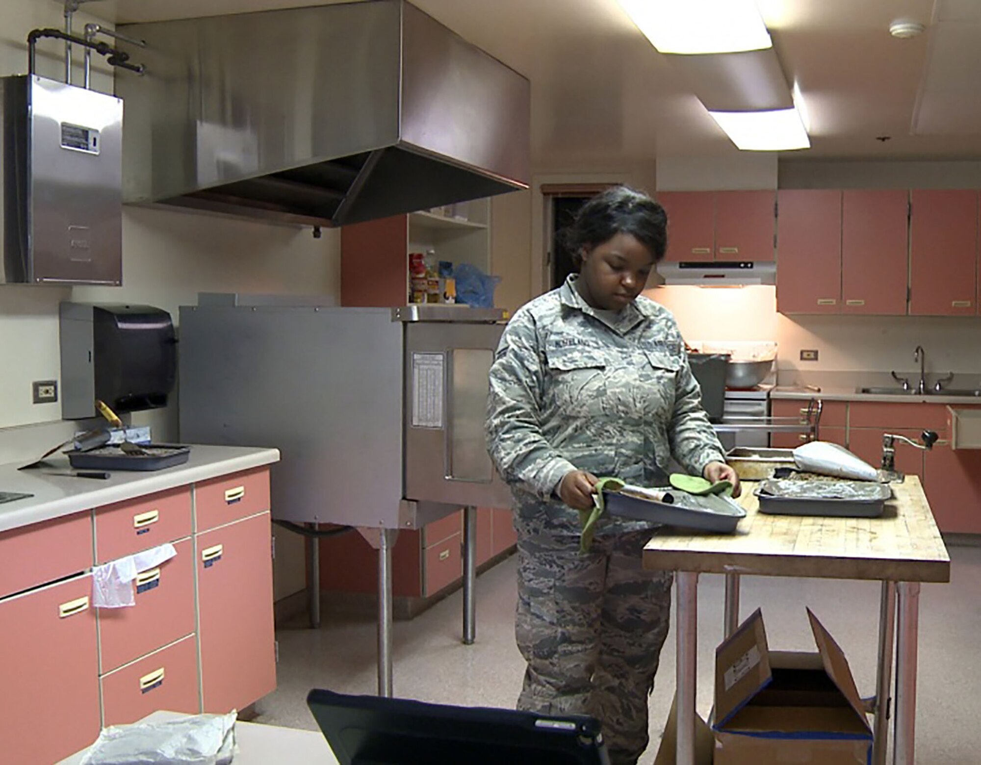Airman 1st Class Mariah Moreland with the 445th Force Support Squadron from Wright-Patterson Air Force Base, Ohio, prepares dinner at the Port Lions School House in Port Lions Village on Kodiak, Alaska, March 28, 2017, for service members participating in ARCTIC CARE 2017 medical readiness exercise. (U.S. Air Force Photo by Tech. Sgt. Wendy Day)