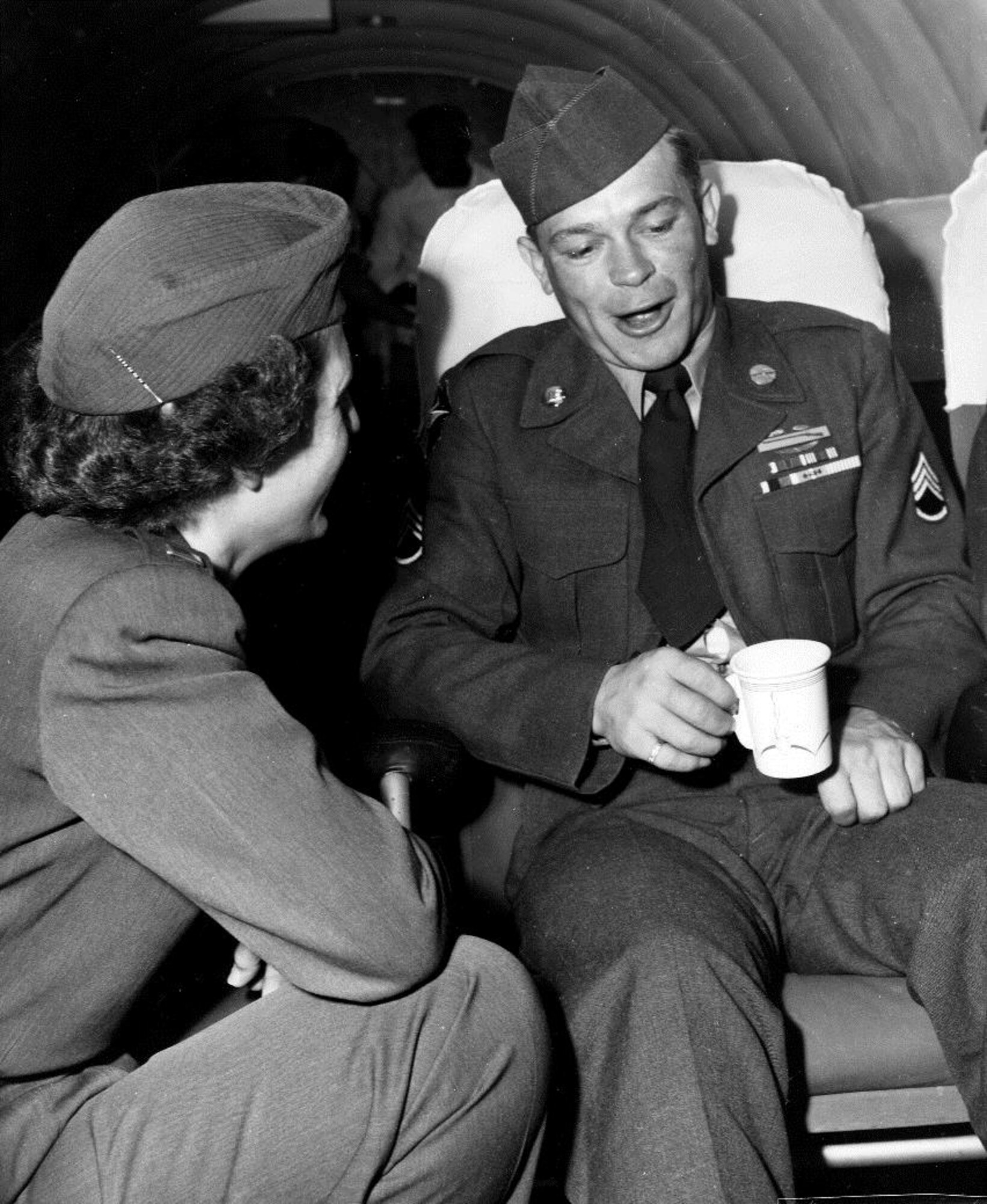 Aboard a Douglas C-47 en route to Kelly Air Force Base, San Antonio, Texas, a former prisoner of war recently repatriated in the UN POW exchange, Army Sgt. Gerald Neighbors, POW, of Amarillo, Texas, talks with USAF flight nurse, Lt. Lemm.   