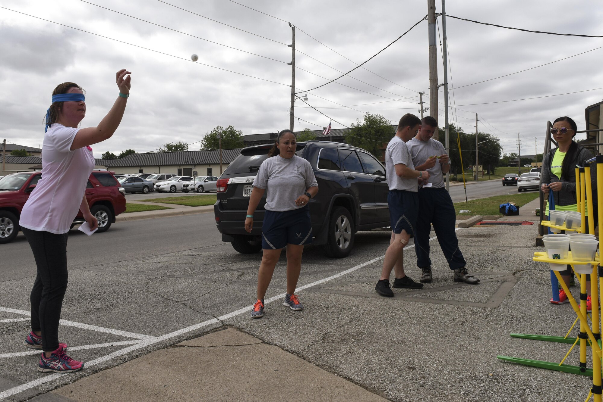 Participants of the 7th annual Sexual Assault Response Coordinator Challenge throw a ping pong ball into cups on Goodfellow Air Force Base, Texas, April 14, 2017. The challenge had to be done blind folded to be allowed to move onto the next task. (U.S. Air Force photo by Airman 1st Class Chase Sousa/Released)