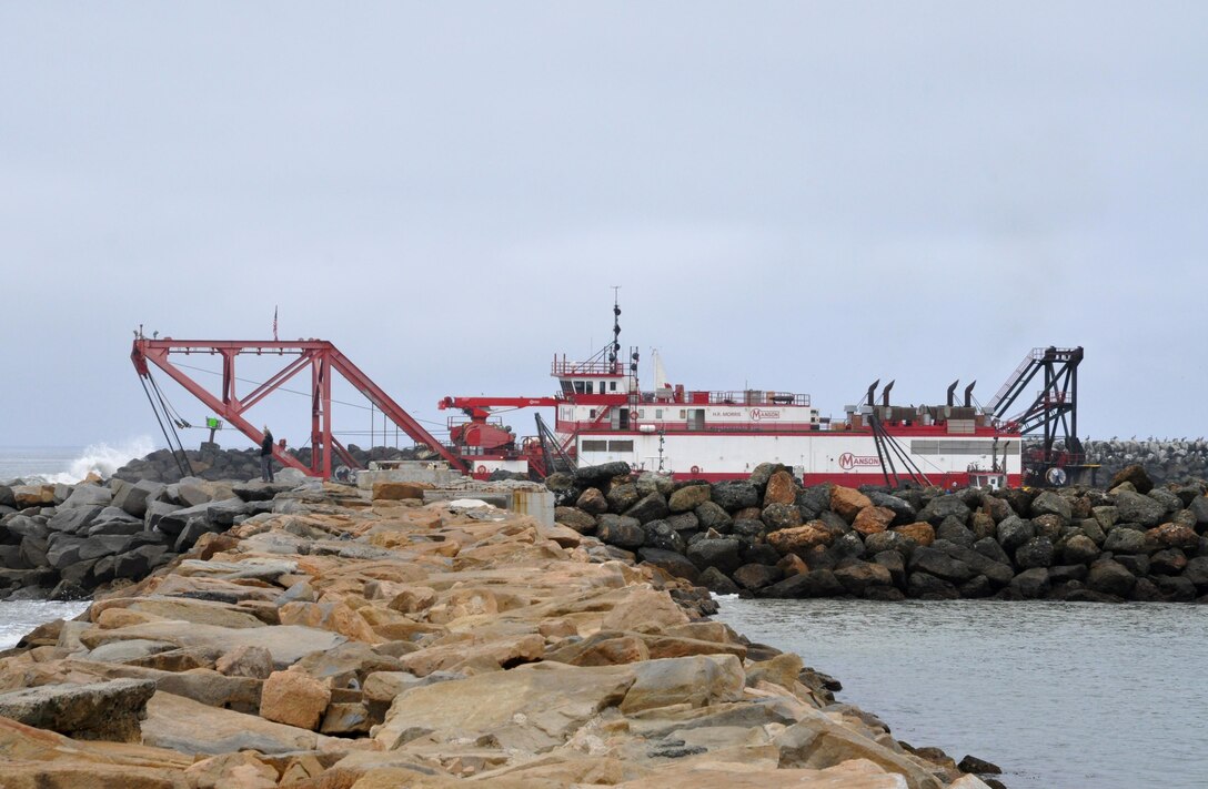 The dredge HR Morris maintains position at the Oceanside Harbor entrance channel as the annual navigation project begins. The dredge pumps sediment from the channel in order to maintain the authorized federal channel depth, with the added benefit of using the material to renourish Oceanside beaches.