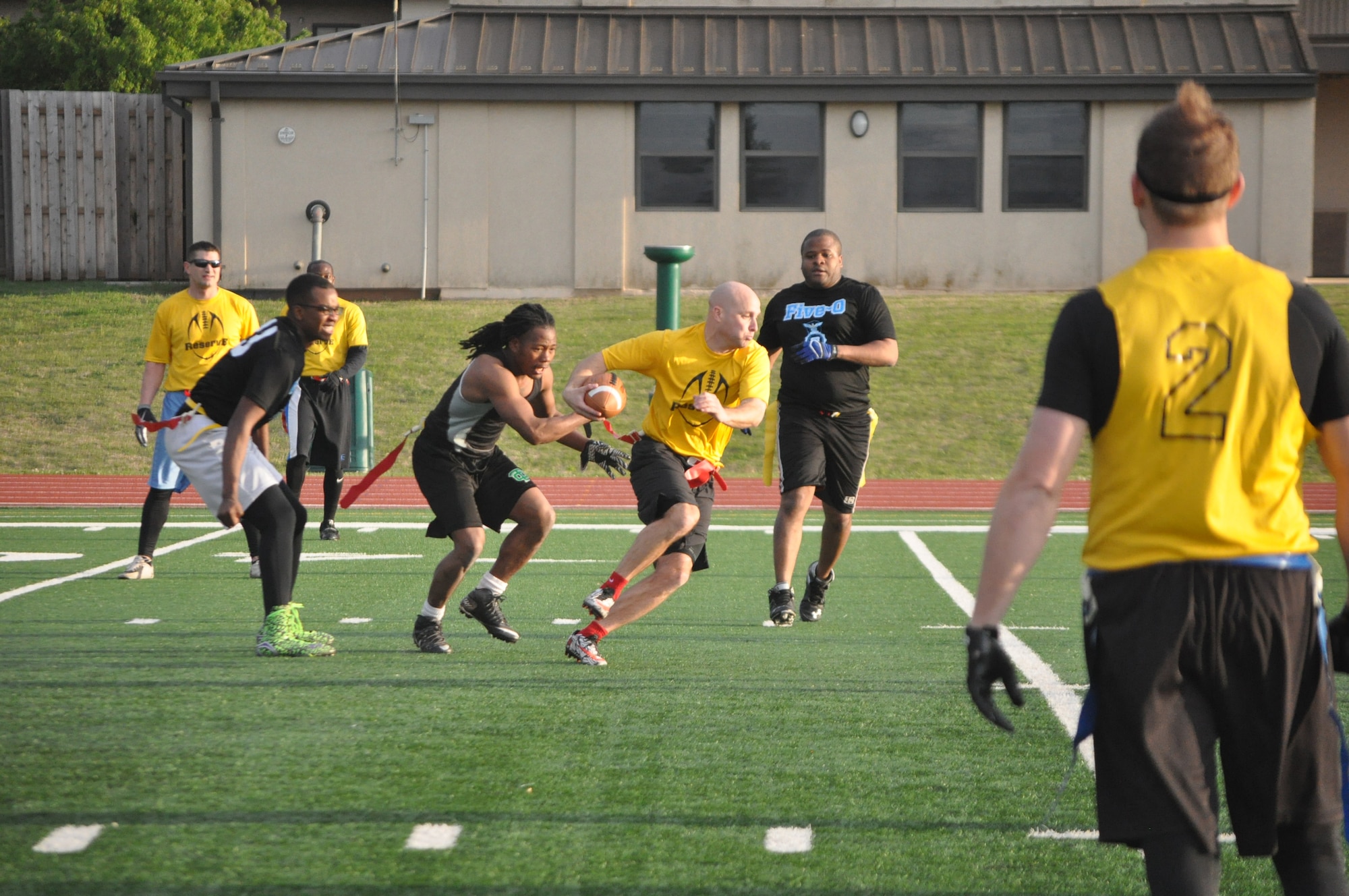 Reserve Gold quarterback Jeff Inferrere sprints to evade three 72nd Security Forces Squadron defenders in the April 4 intramural flag football game near the dorms. Gold won 22-6. (Air Force photo by John Parker)