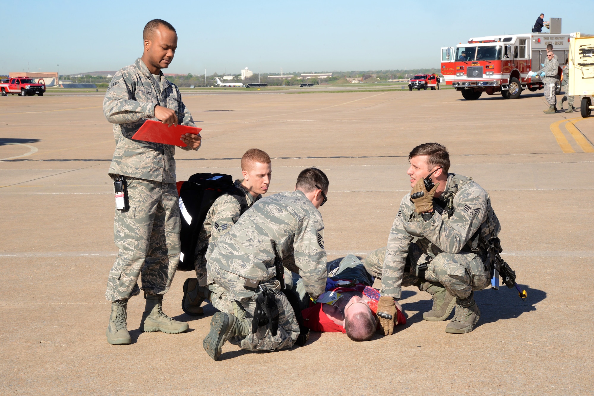 Medics with the 72nd Medical Group, along with members of the 72nd Security Forces Squadron, help stabilize a moulage victim during the April 6 emergency response exercise. About 150 volunteers helped bring to life a more realistic-feeling exercise, which enabled first responders to know how to better react in real world situations. (Air Force photo by Kelly White)
