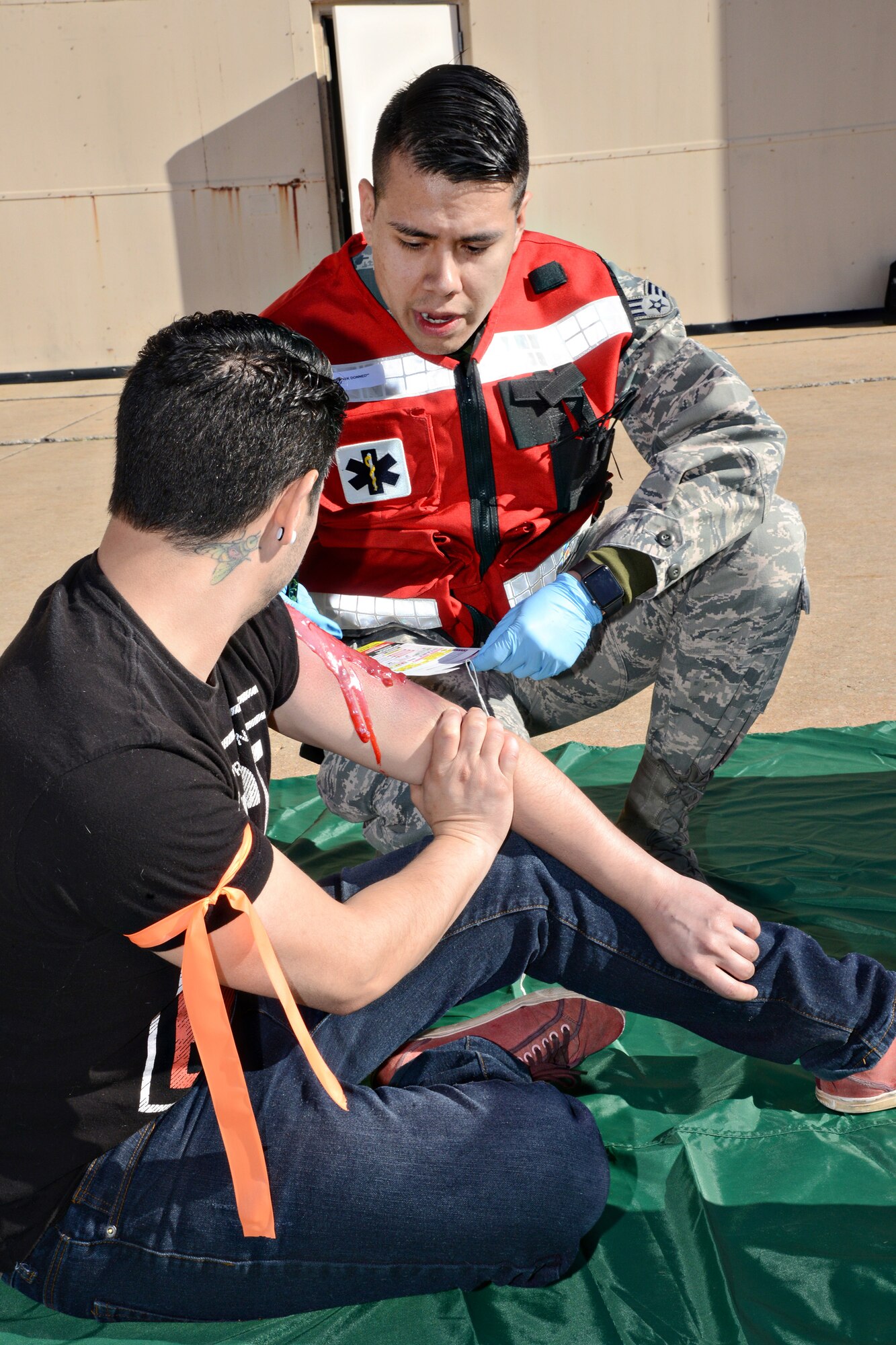 Senior Airman TsisTsisTsas Tall Bear, with the 72nd Medical Operations Squadron, fills out a triage tag for Leo Guerrero, a moulage victim, during the April 6 emergency response exercise. (Air Force photo by Kelly White)