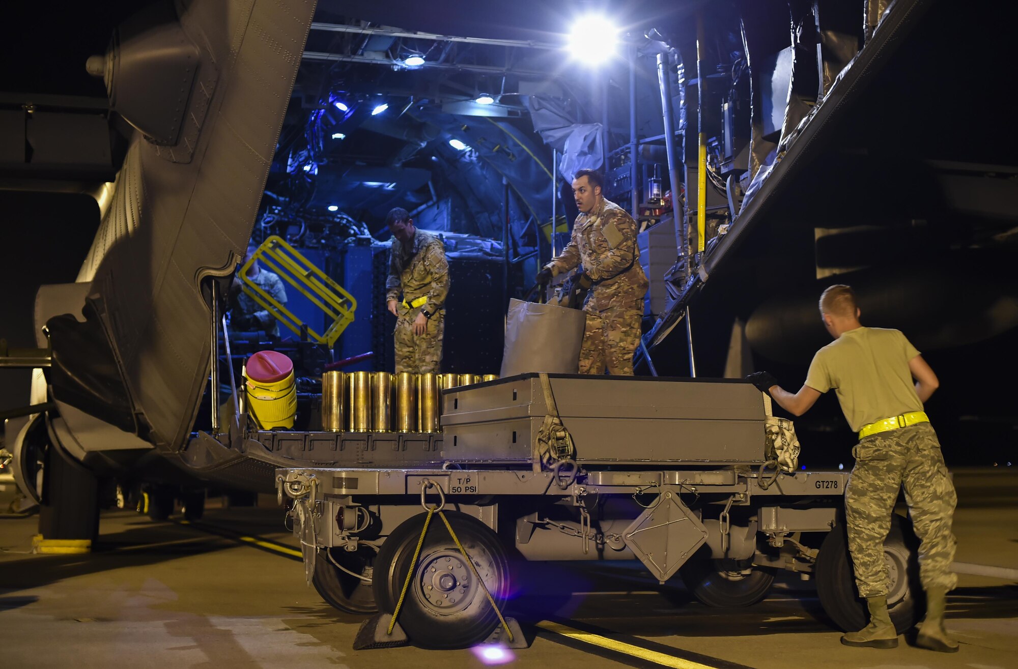 Staff Sgt, Shane Hayes, center, a special missions aviator with the 4th Special Operations Squadron, offloads 40mm round shells from an AC-130U Spooky gunship at Hurlburt Field, Fla., April 17, 2017. Aircrew with the 4th SOS conducted a live-fire training mission to ensure mission readiness any time, any place. (U.S. Air Force photo by Airman 1st Class Joseph Pick)