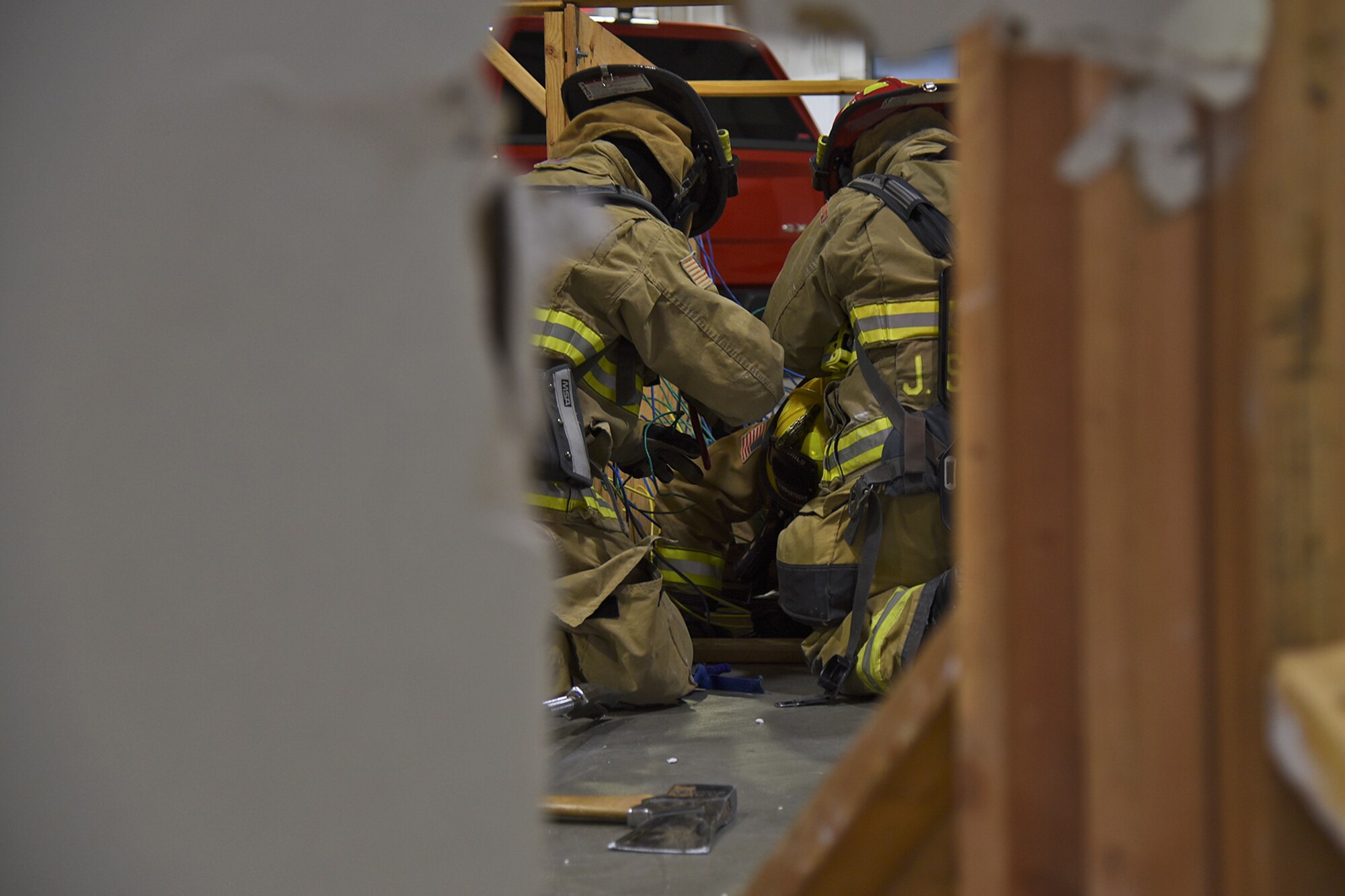 92nd Civil Engineer Squadron firefighters rescue a down firefighter from the entanglement trainer during a demonstration of their Rapid Intervention Crew training Mar. 29, 2017, at Fairchild Air Force Base, Washington. The demonstration was part of a visit by Col. James Kossler, Air Force Installation and Mission Support Center Detachment 9 commander, to show the progression and implementation of RIC training. (U.S. Air Force photo/Senior Airman Mackenzie Richardson)