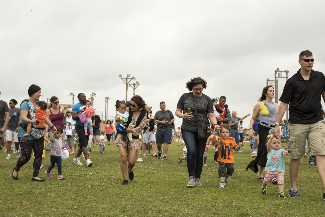 Families race to collect Easter eggs scattered on the Four Diamonds softball field April 15, 2017, at Kadena Air Base, Japan. The Eggsplosion, an annual event hosted by the 18th Force Support Squadron, featured egg hunts for different age groups and also hosted a “Kiddie Land” area with amusement rides designed for children. (U.S. Air Force photo by Senior Airman Omari Bernard/Released)