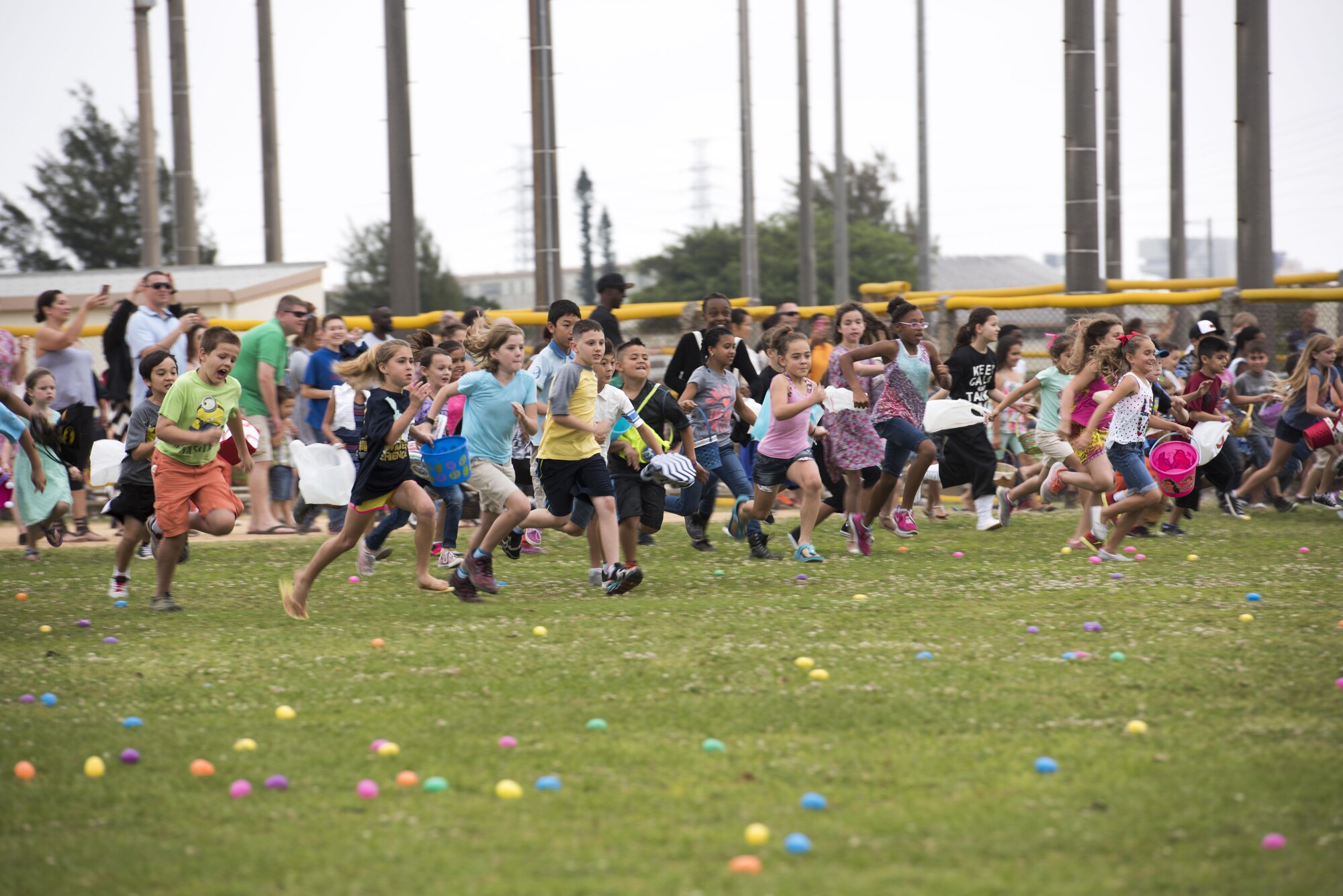 Children race to collect Easter eggs scattered on the Four Diamonds Softball Field April 15, 2017, at Kadena Air Base, Japan. The Eggsplosion, an annual event hosted by the 18th Force Support Squadron, had egg hunts for different age groups, cultural demonstrations, food and prizes. Volunteers hid more than 50,000 eggs for the children to find. (U.S. Air Force photo by Senior Airman Omari Bernard/Released)
