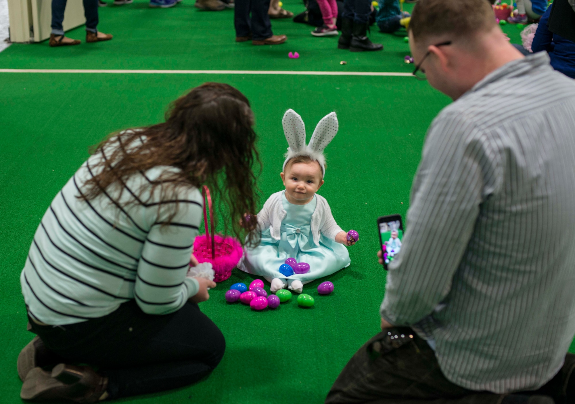 Parents take a photo of their child during an Easter egg hunt at Misawa Air Base, Japan, April 15, 2017. Parents watched their children collect Easter eggs at the event, held by the 35th Force Support Squadron. (U.S. Air Force photo by Senior Airman Brittany A. Chase)