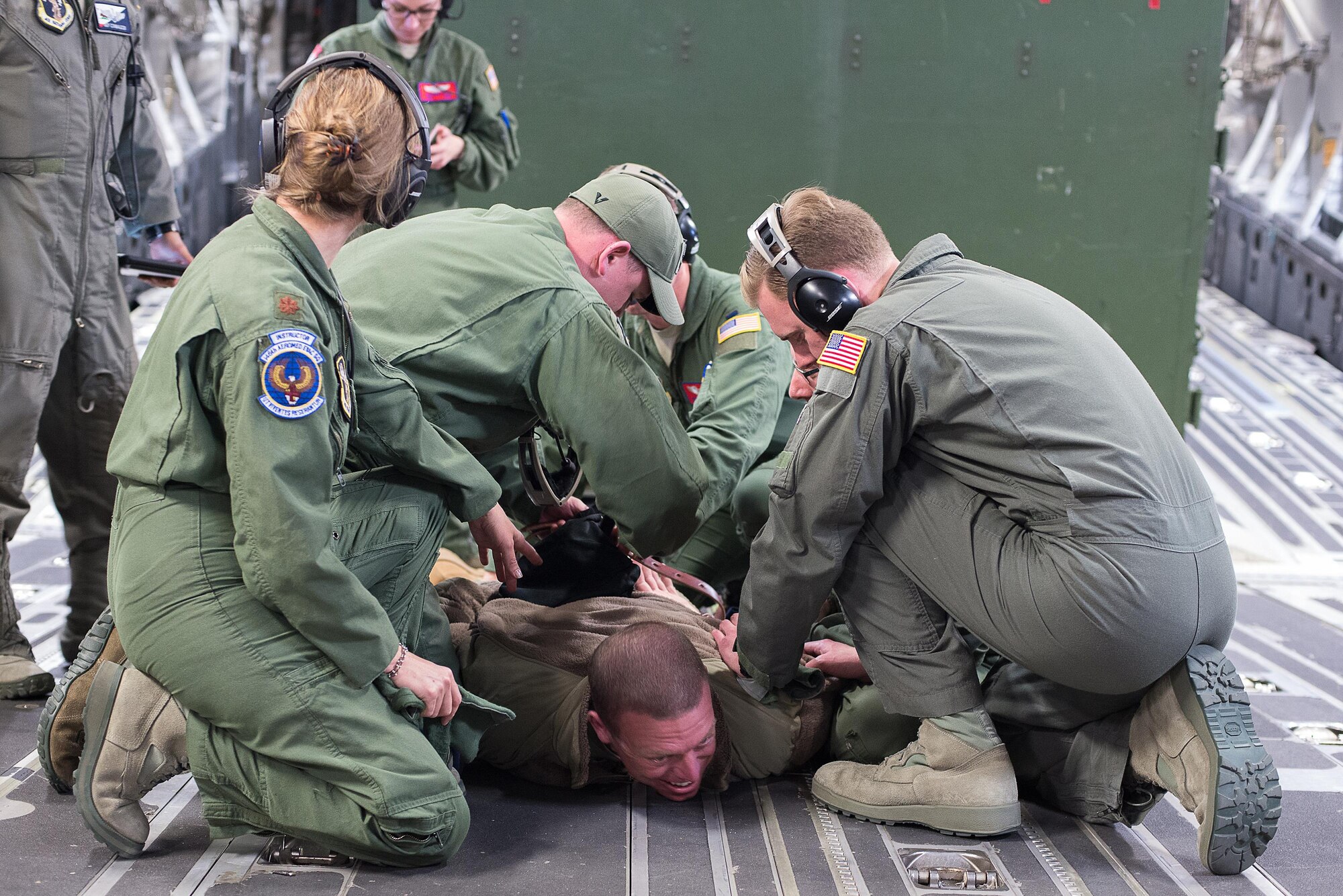 Master Sgt. Joshua Manhart, a volunteer simulated patient, simulates having a mental breakdown and being restrained by aeromedical technicians from the 146th Aeromedical Evacuation Squadron, California Air National Guard, while training on a C-17 Globemaster III during the Multiple Aircraft Training Opportunity Program (MATOP) organized by the 137th Aeromedical Evacuation Squadron from Will Rogers Air National Guard Base, Oklahoma City, April 7, 2017. Airmen of the 137 AES were joined by eight of the nine Air National Guard aeromedical evacuation squadrons as they hosted the annual training event and accomplished mandatory annual aeromedical training requirements. (U.S. Air National Guard photo by Senior Master Sgt. Andrew M. LaMoreaux/Released)