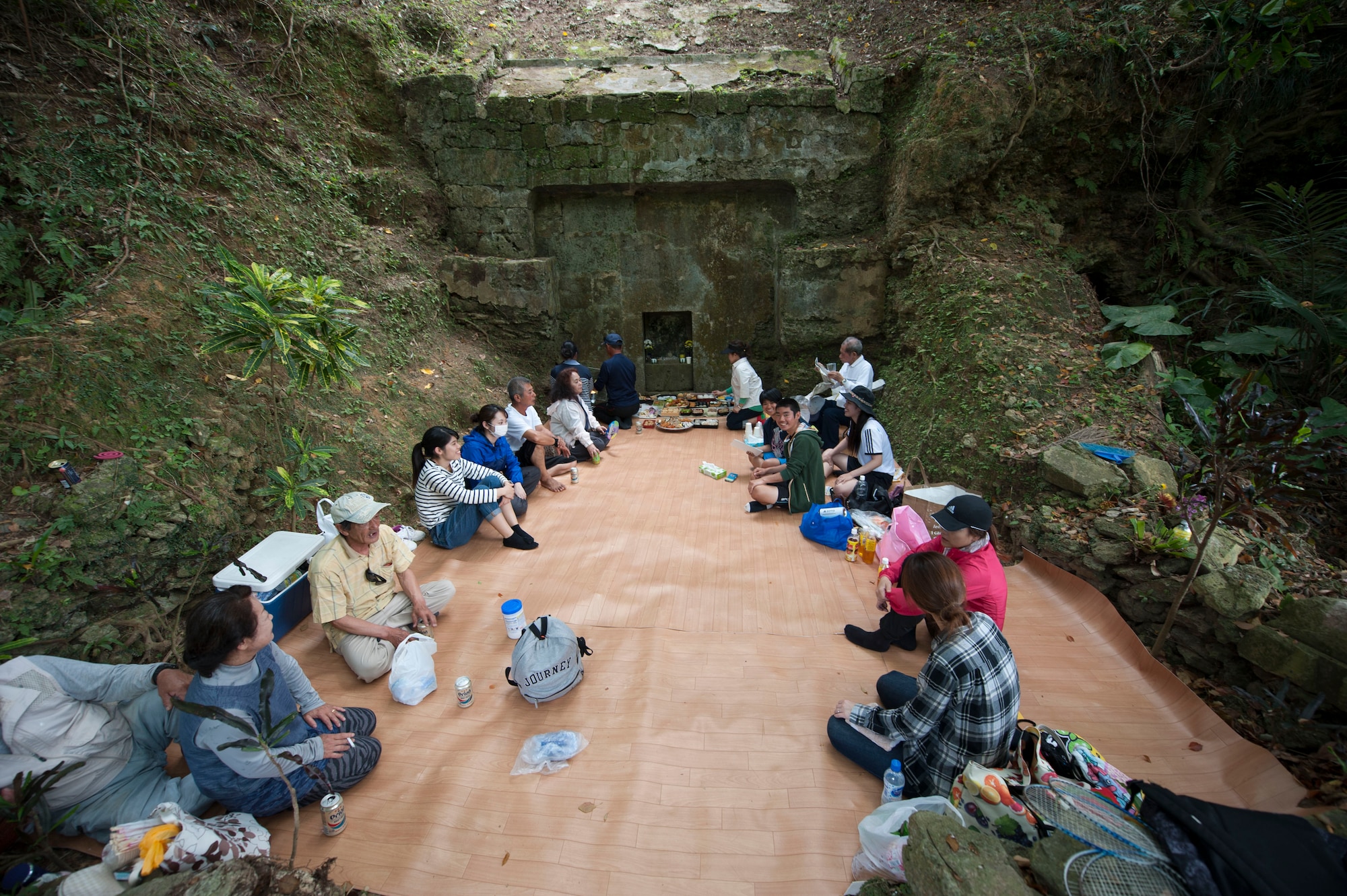 The Yamauchi family sits together at their family tomb April 9, 2017, at Kadena Air Base, Japan. Members of the family partook in traditional rituals meant to honor their ancestors. (U.S. Air Force photo by Airman 1st Class Quay Drawdy)
