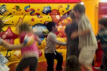 Spangdahlem community children bounce in an inflatable castle during the fourth annual Spring Fling event in the Base Exchange at Spangdahlem Air Base, Germany, April 14, 2017. The Exceptional Family Member Program teamed up with other various organizations to host the event during month of the military child. The focus was to raise awareness for the EFMP and the service it provides for families. (U.S. Air Force photo by Airman 1st Class Preston Cherry)