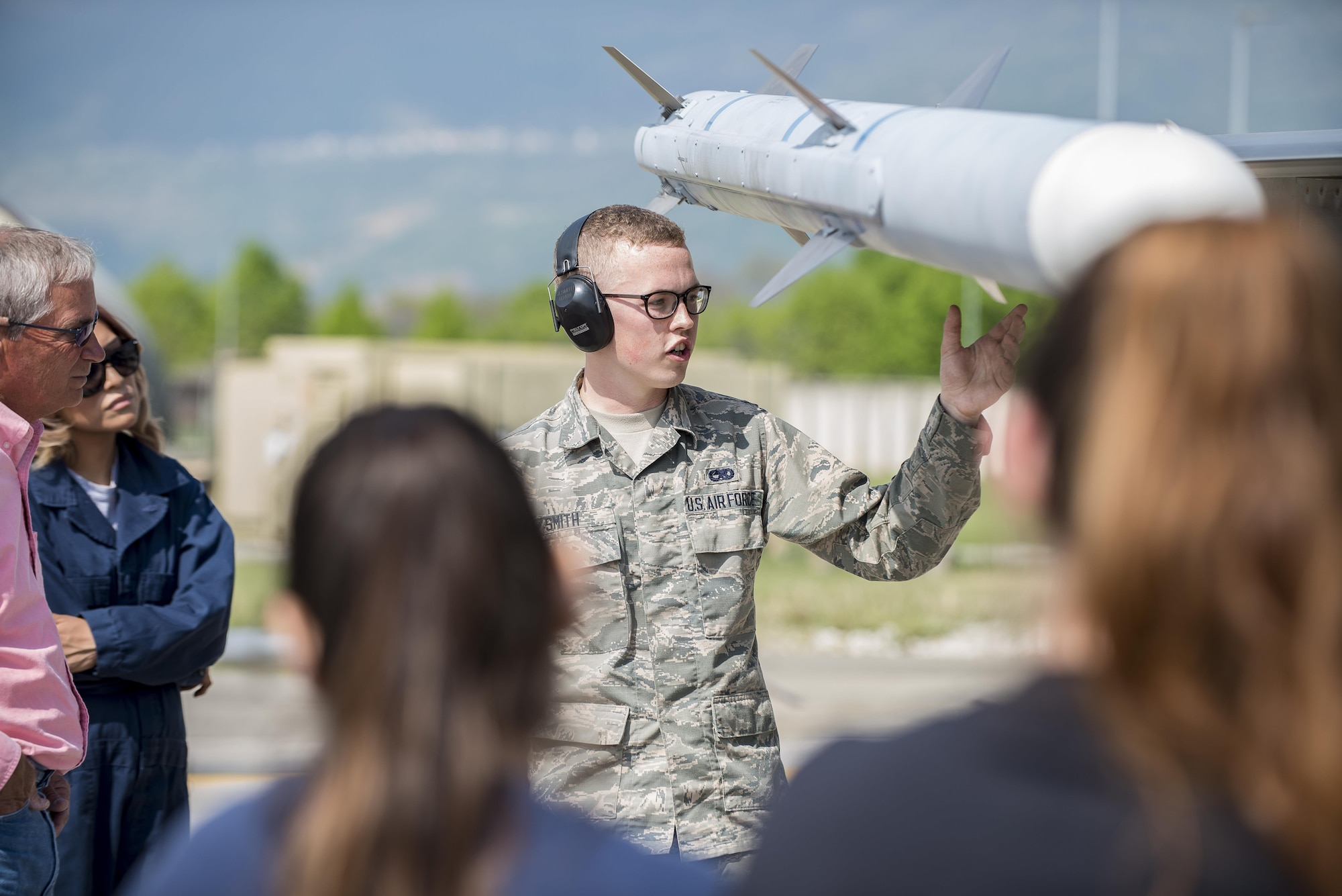Airman Jordan Smith, 31st Aircraft Maintenance Squadron weapons loader crewmember, demonstrates how an air-to-air munition works during a Spouses’ Appreciation Day event at Aviano Air Base, Italy, April 12, 2017. The spouses learned how to use a munitions load vehicle to load munitions on an F-16 Fighting Flacon. (U.S. Air Force photo by Senior Airman Cory W. Bush)
