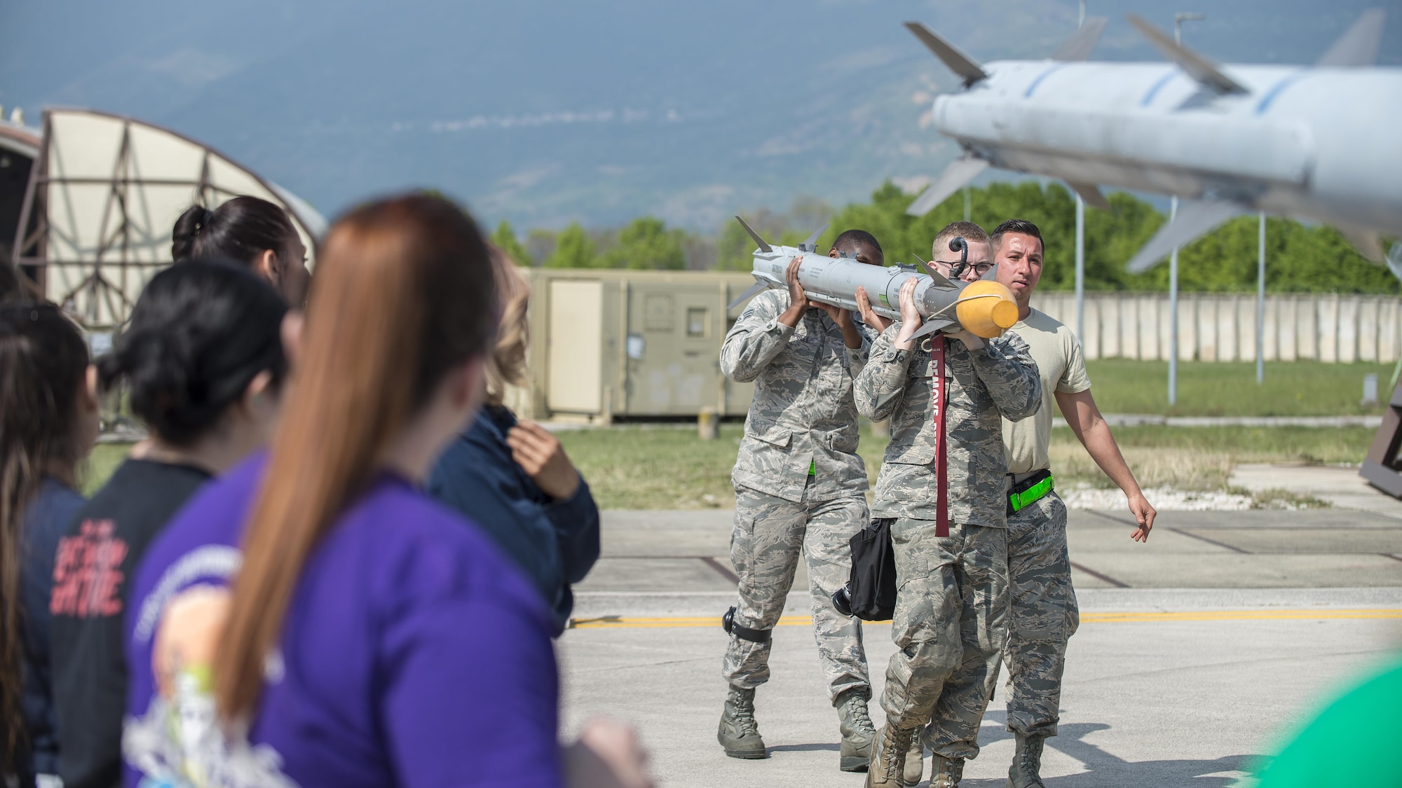 31st Aircraft Maintenance Squadron weapons loader crewmembers, demonstrate how to load munitions during a Spouses’ Appreciation Day event at Aviano Air Base, Italy, April 12, 2017. Throughout the day, spouses performed an intake and exhaust check, operated a targeting pod, helped load munitions, completed a wire repair, and even swapped out an F-16 Fighting Falcon tire. (U.S. Air Force photo by Senior Airman Cory W. Bush)