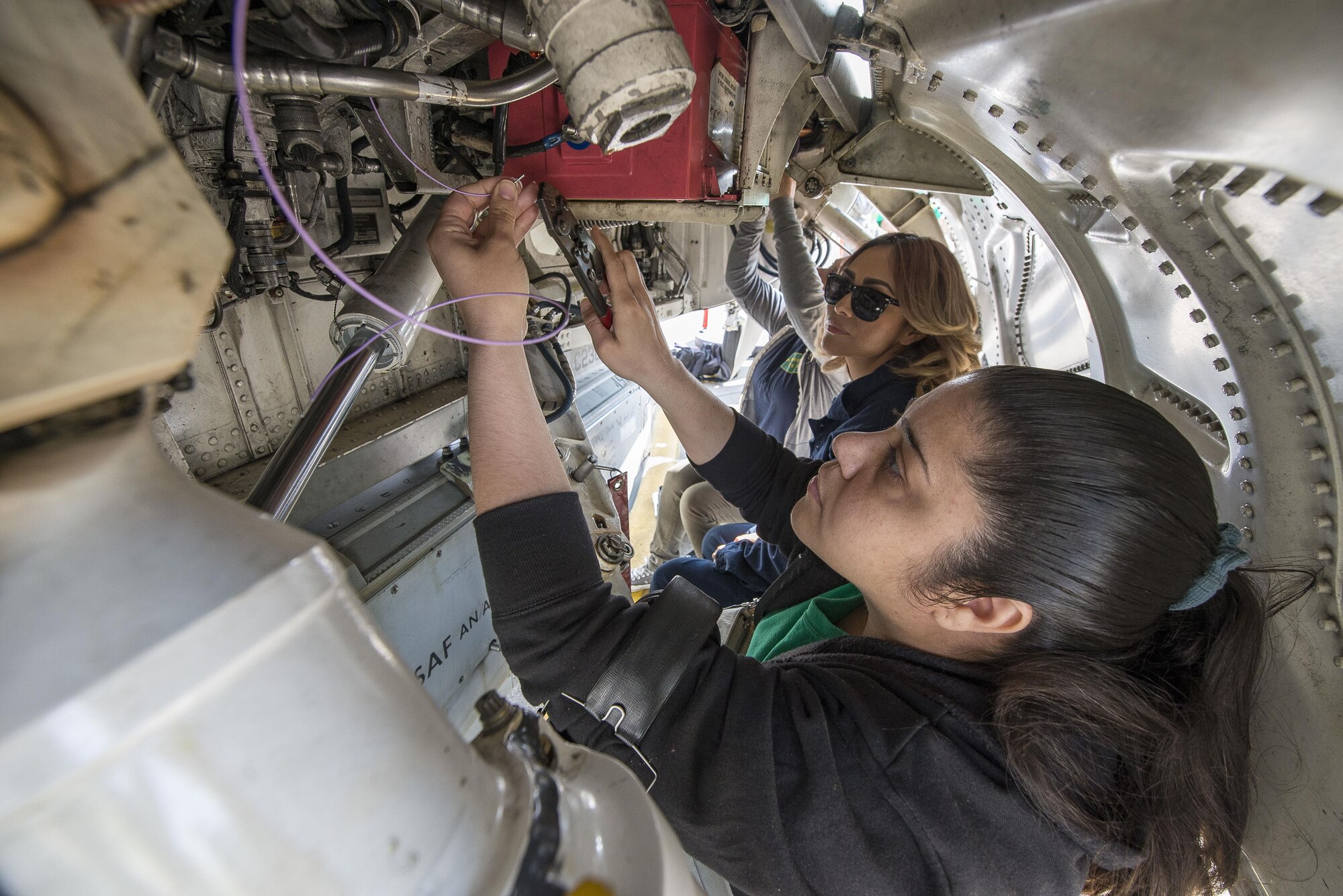 Karla Toledo, Karri Wahedi, and Sierra Morre, 31st Aircraft Maintenance Squadron spouses, perform cable maintenance on an F-16 Fighting Falcon during a Spouses’ Appreciation Day event at Aviano Air Base, Italy, April 12, 2017. The day was hosted to help honor spouses for their everyday sacrifices on the homefront. (U.S. Air Force photo by Senior Airman Cory W. Bush)