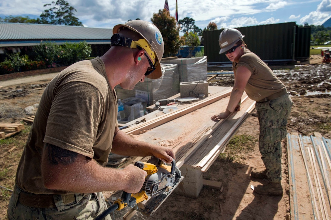 Navy Petty Officer 3rd Class Justin Hargett and Petty Officer 3rd Class Allison Machicek cut pieces of exterior trim for renovations at Sungai Pinang Primary School, an engineering site of Pacific Partnership 2017 in Kuching, Malaysia, April 17, 2017. Navy photo by Petty Officer 2nd Class Chelsea Troy Milburn