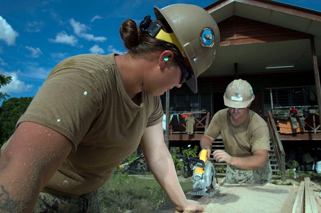 Navy Petty Officer 3rd Class Allison Machicek assists Navy Petty Officer 3rd Class Justin Hargett as he uses a skill saw to cut pieces of exterior trim for renovations at Sungai Pinang Primary School, an engineering site of Pacific Partnership 2017 in Kuching, Malaysia, April 17, 2017. Navy photo by Petty Officer 2nd Class Chelsea Troy Milburn