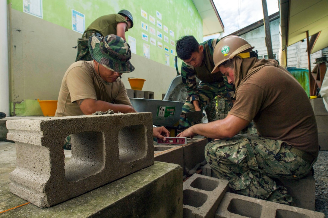 Navy Petty Officer 3rd Class Andrew Boria works with Malaysian army engineers to lay and level brick and mortar at Binyu Primary School, an engineering site of Pacific Partnership 2017 in Kuching, Malaysia, April 17, 2017. Navy photo by Petty Officer 2nd Class Chelsea Troy Milburn